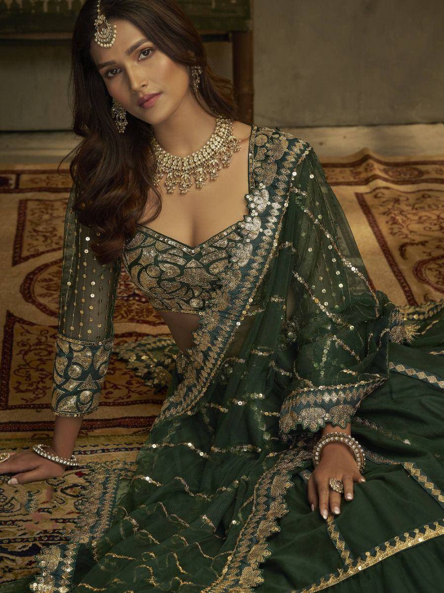 Emerald green designer lehenga choli with gold embroidery and sequins, perfect for Indian weddings and festive occasions.