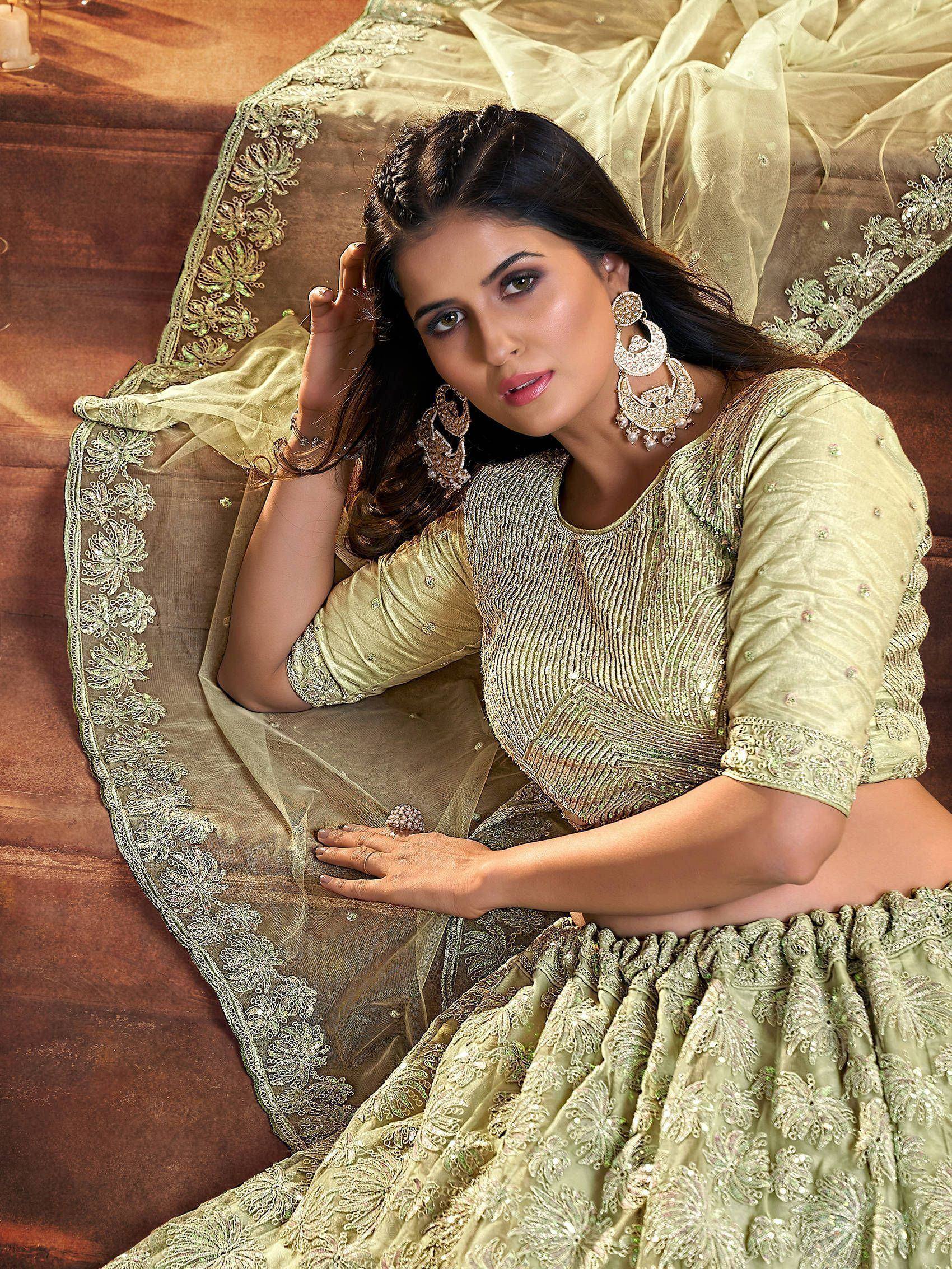 Elegant light green designer lehenga choli with intricate embroidery and sequin work, perfect for Indian ethnic occasions.