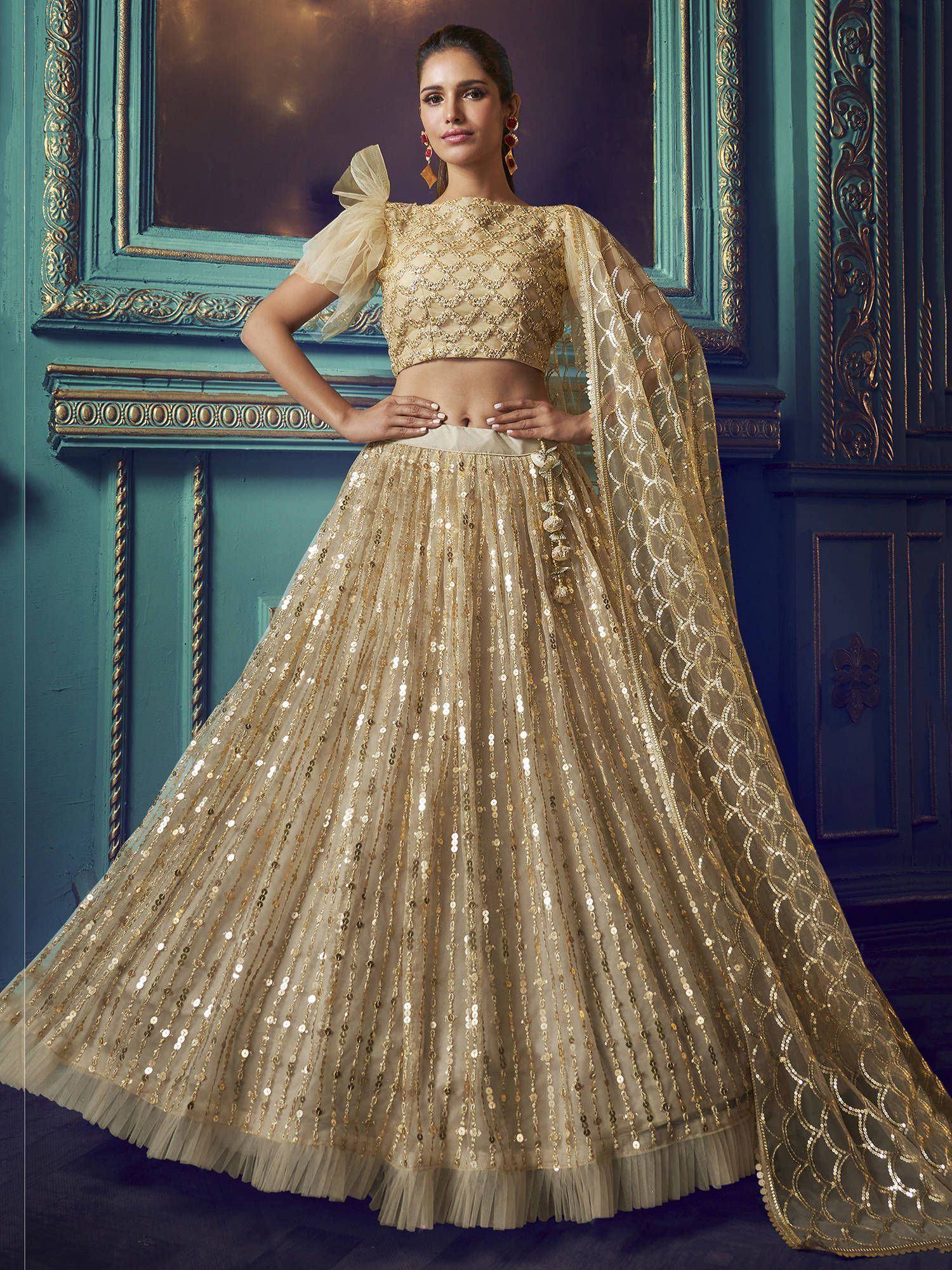 Golden sequin lehenga choli with embroidered crop top and sheer dupatta, perfect for Indian weddings and festive occasions.