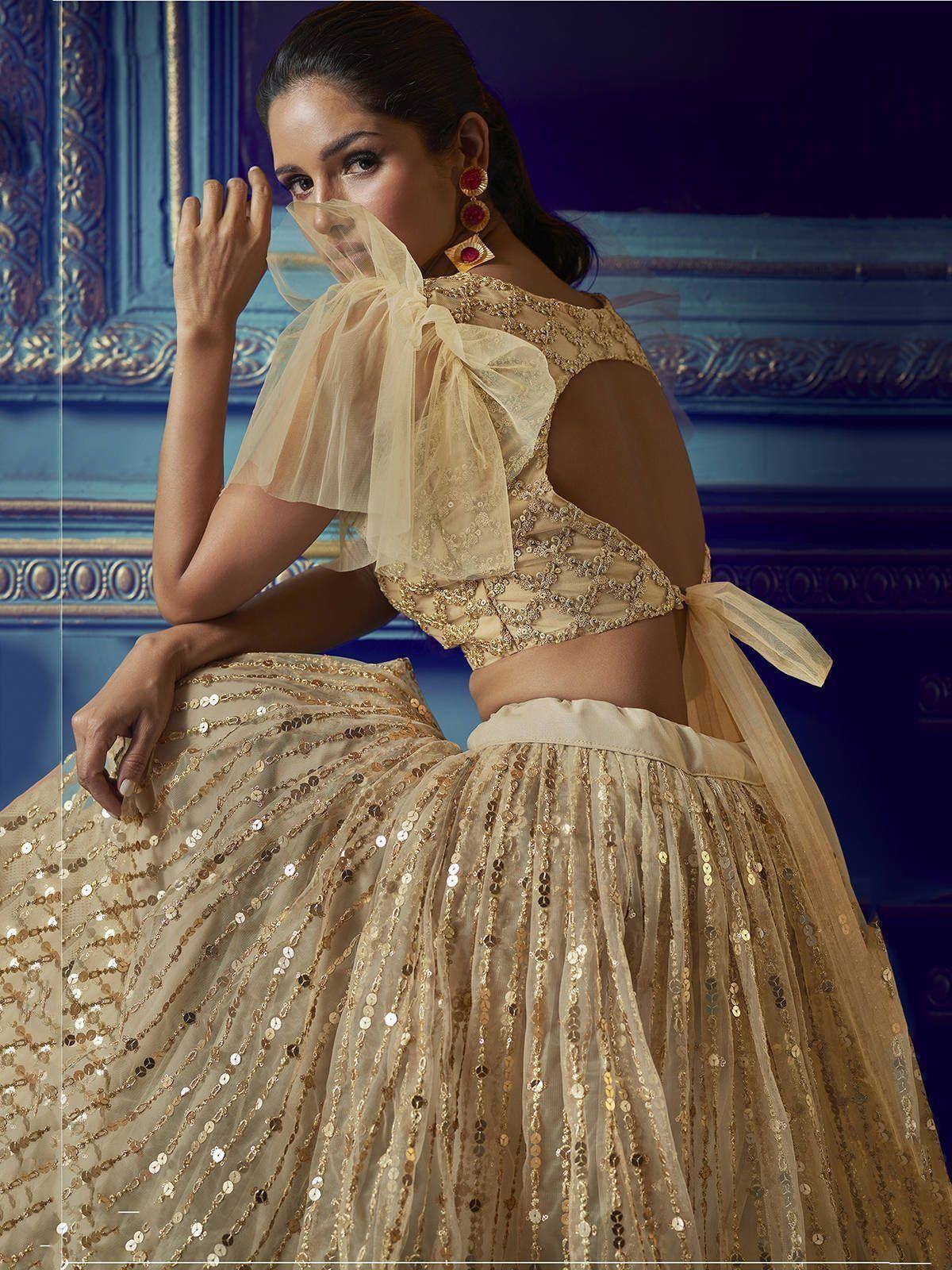 Elegant gold sequin lehenga choli with sheer bow blouse, perfect for Indian weddings and festive occasions