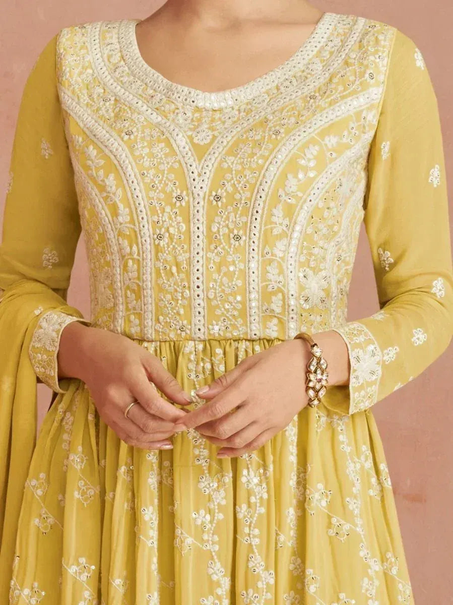 Woman wearing yellow embroidered ethnic gown with floral patterns and long sleeves