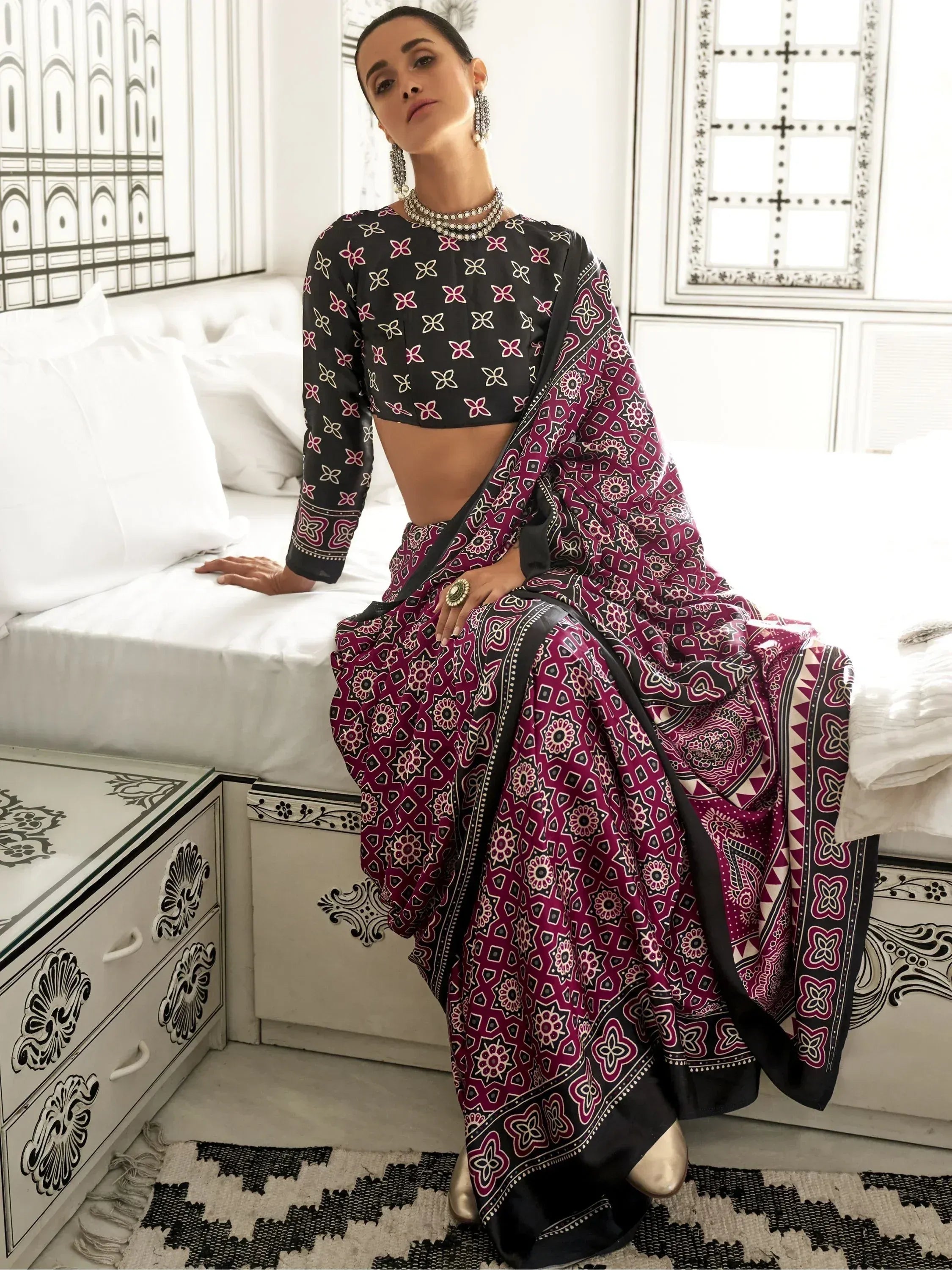 Woman in black and maroon printed ethnic saree with floral blouse, styled with statement jewelry for Indian occasions