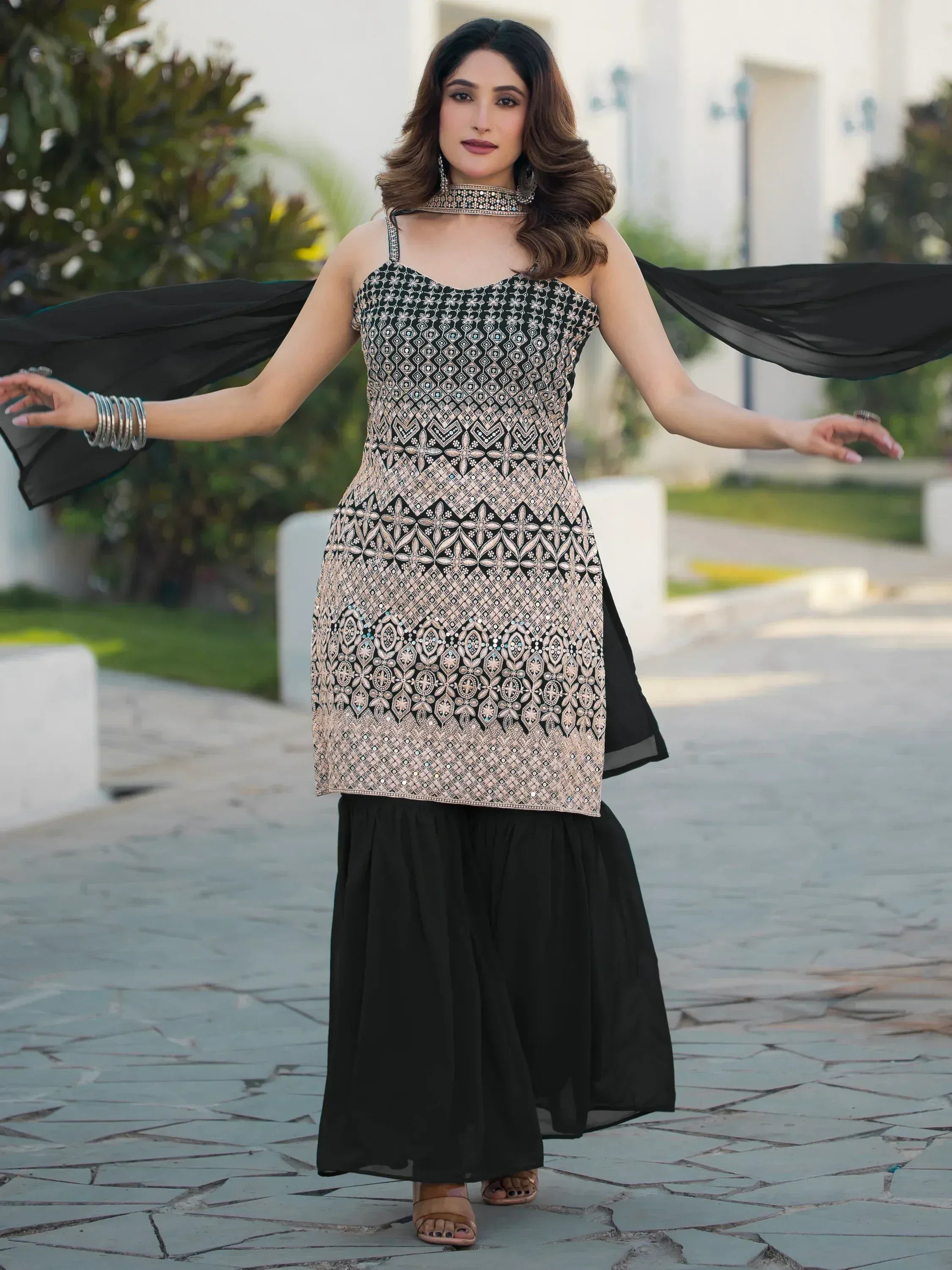 Elegant black and gold embroidered ethnic gown with flowing dupatta, perfect for Indian occasions.