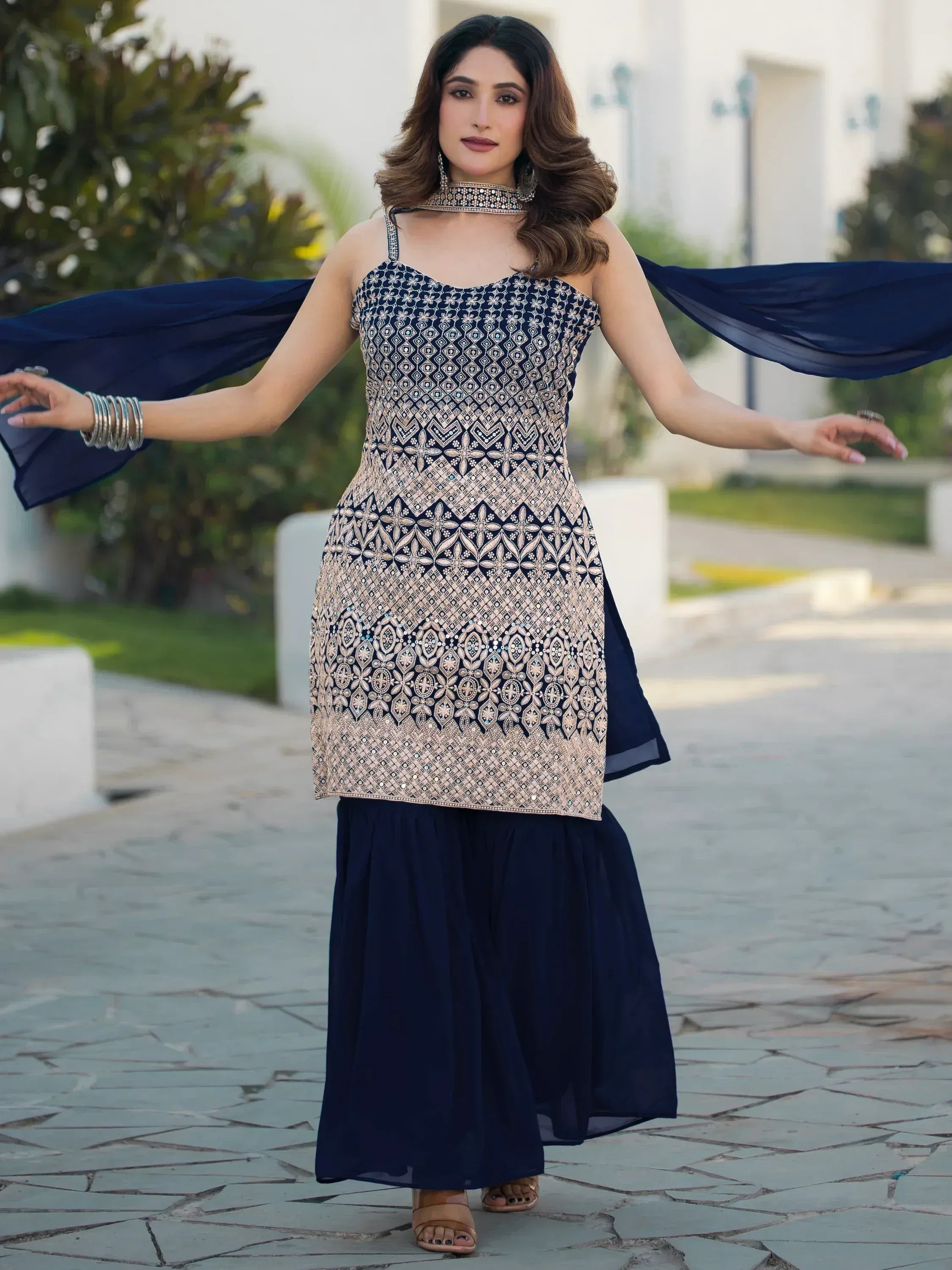 Navy blue ethnic gown with gold embroidery, paired with matching dupatta, perfect for Indian occasions.