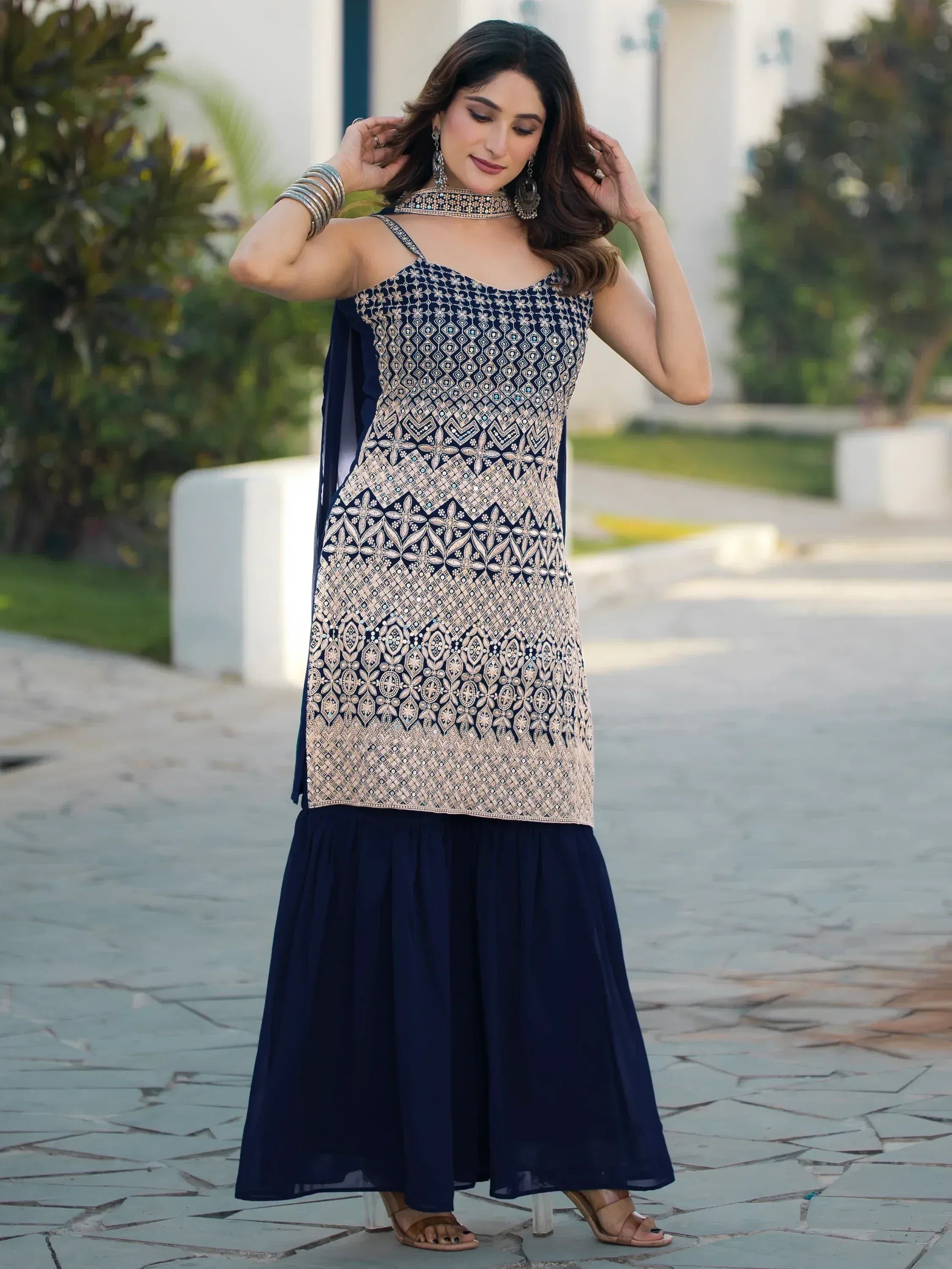 Elegant navy blue ethnic gown with intricate gold embroidery, perfect for Indian festive occasions.