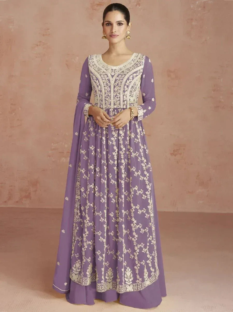 Woman wearing a lavender embroidered ethnic gown with long sleeves and gold floral patterns