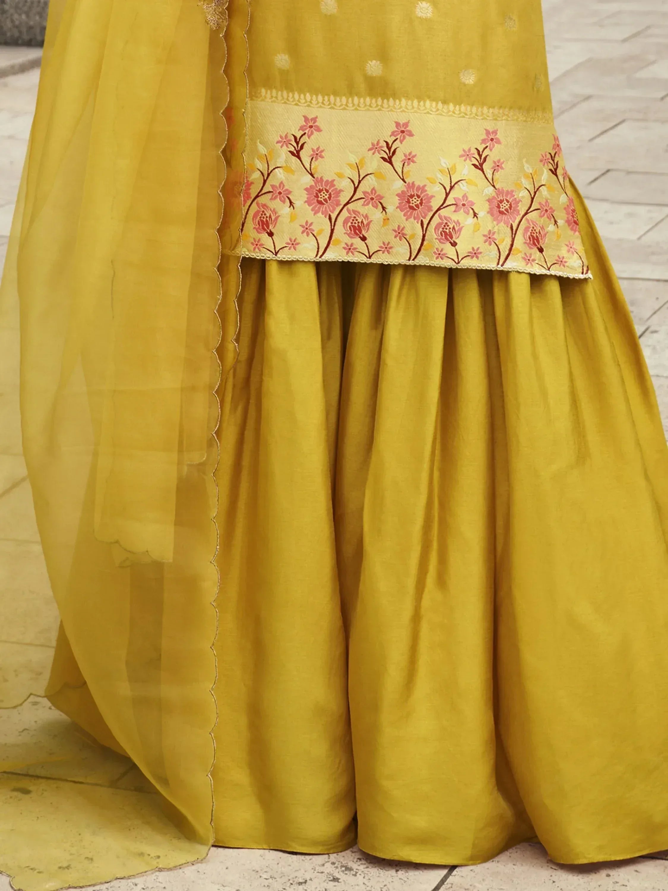 Yellow ethnic lehenga with pink floral embroidery and sheer dupatta, perfect for Indian celebrations.