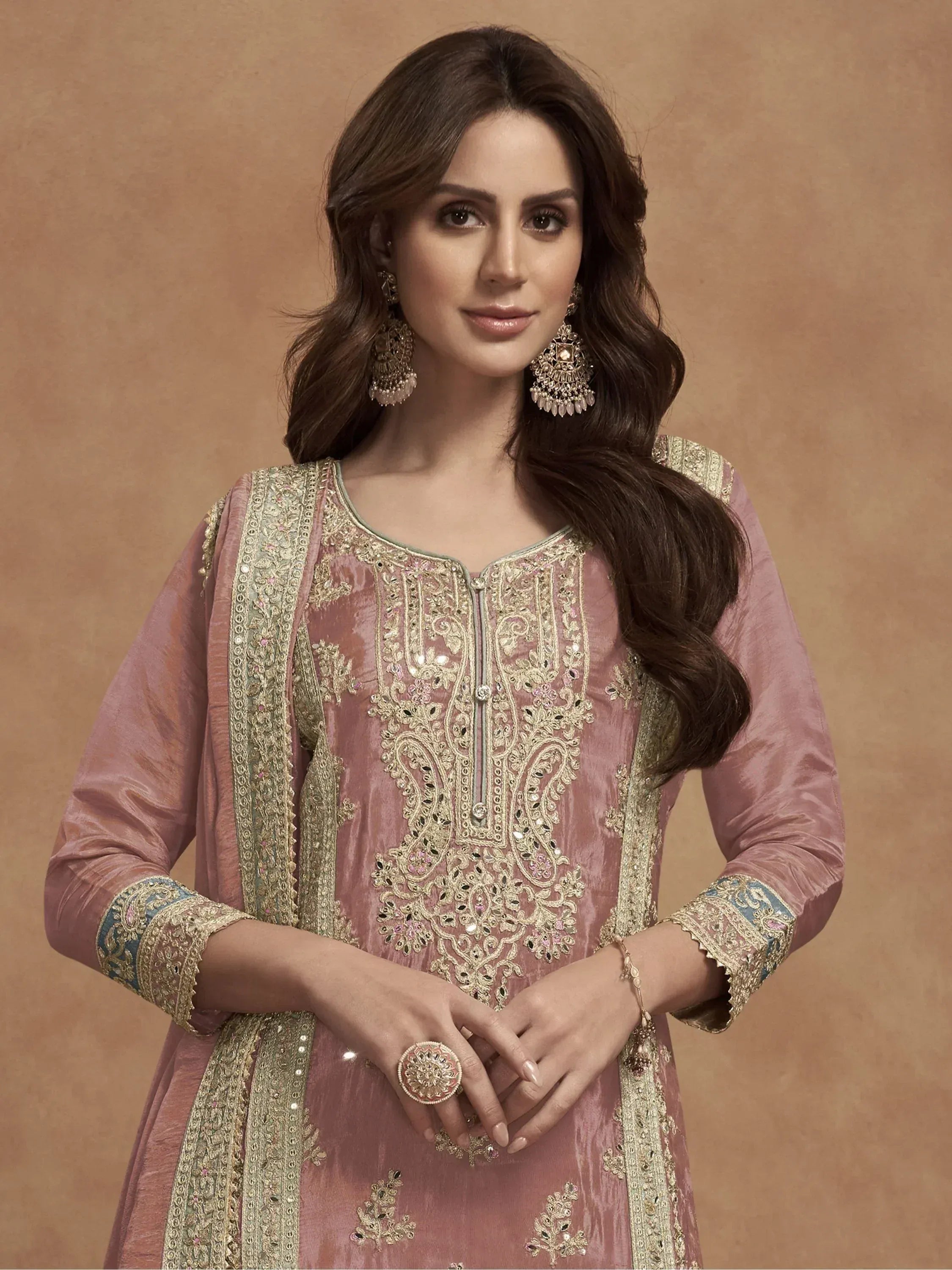 Elegant pink embroidered salwar kameez with gold detailing and traditional jewelry