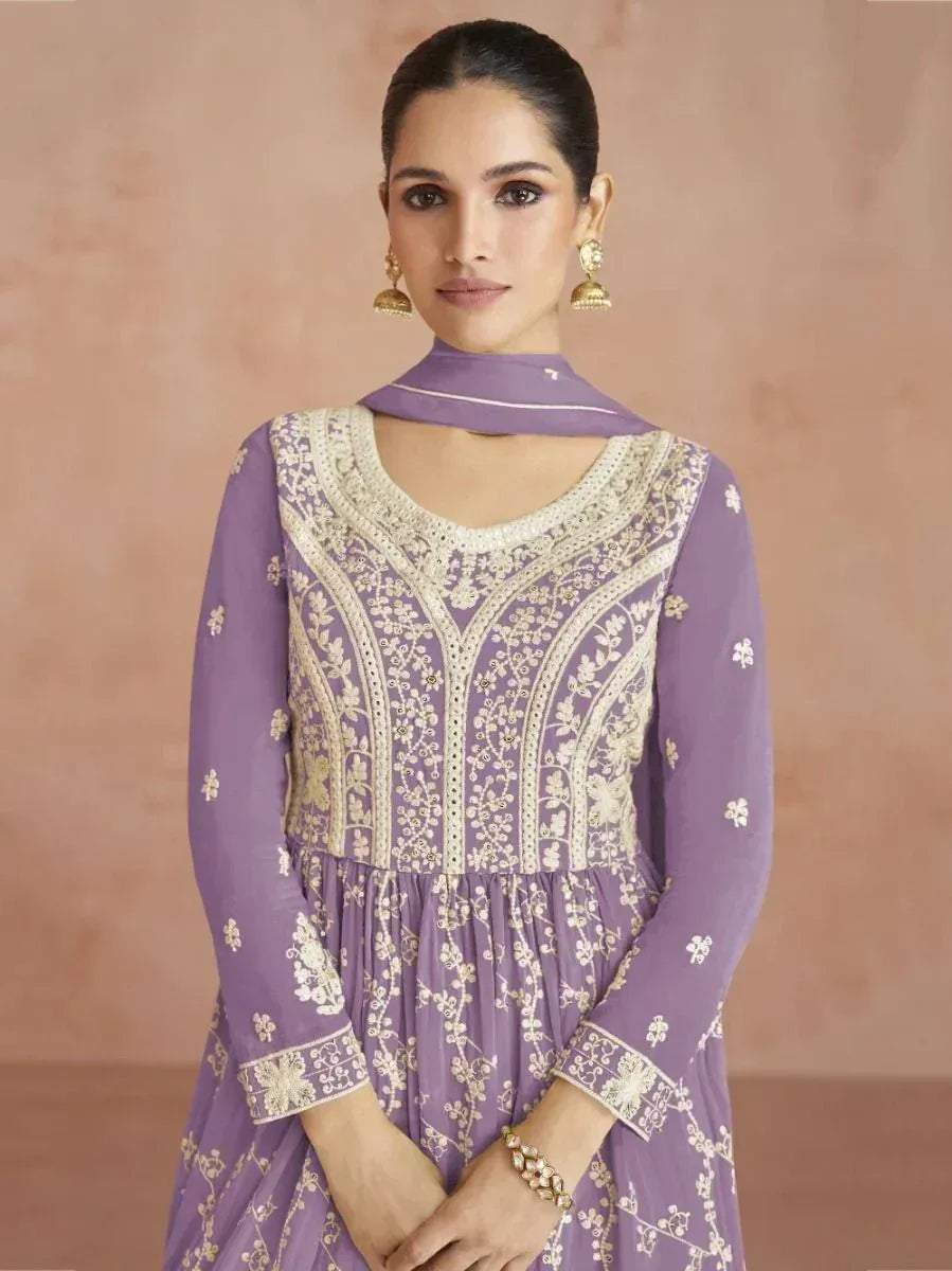 Woman in lavender embroidered ethnic gown with dupatta and traditional jhumka earrings