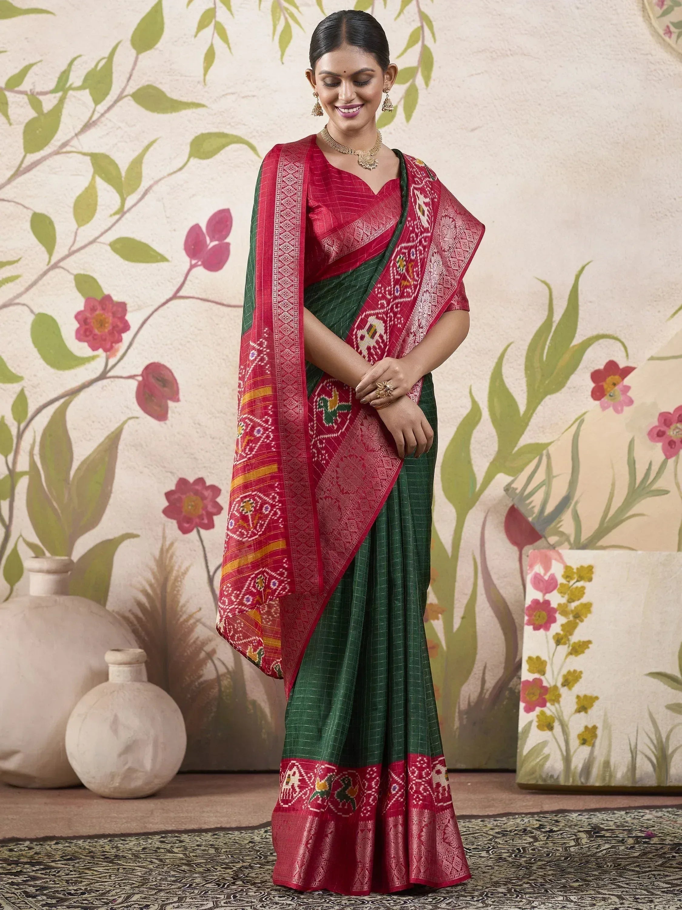 Woman in red and green ethnic saree with intricate embroidery, perfect for Indian occasions