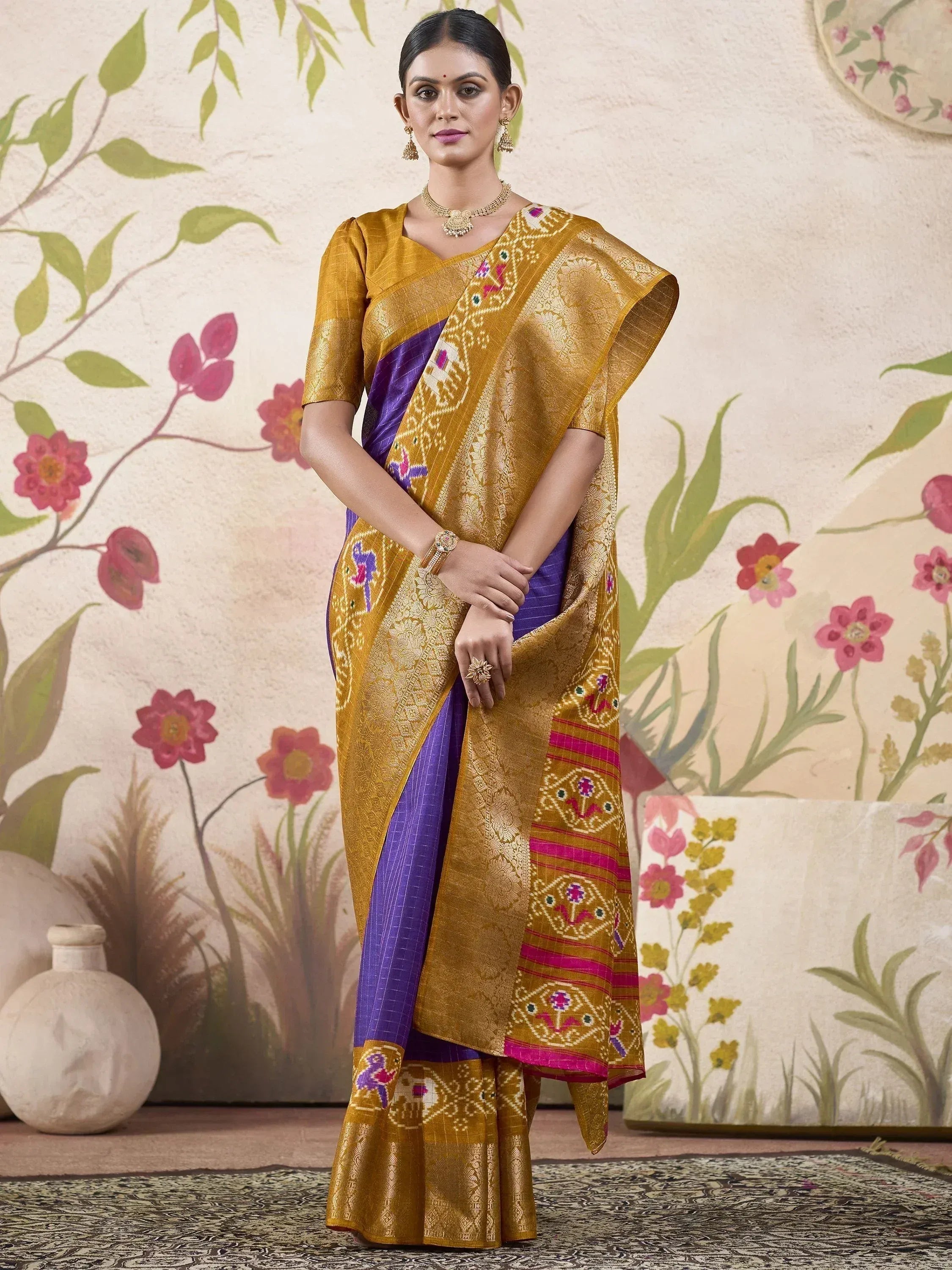 Woman in mustard and purple designer saree with embroidered border, ethnic wear for festive occasions