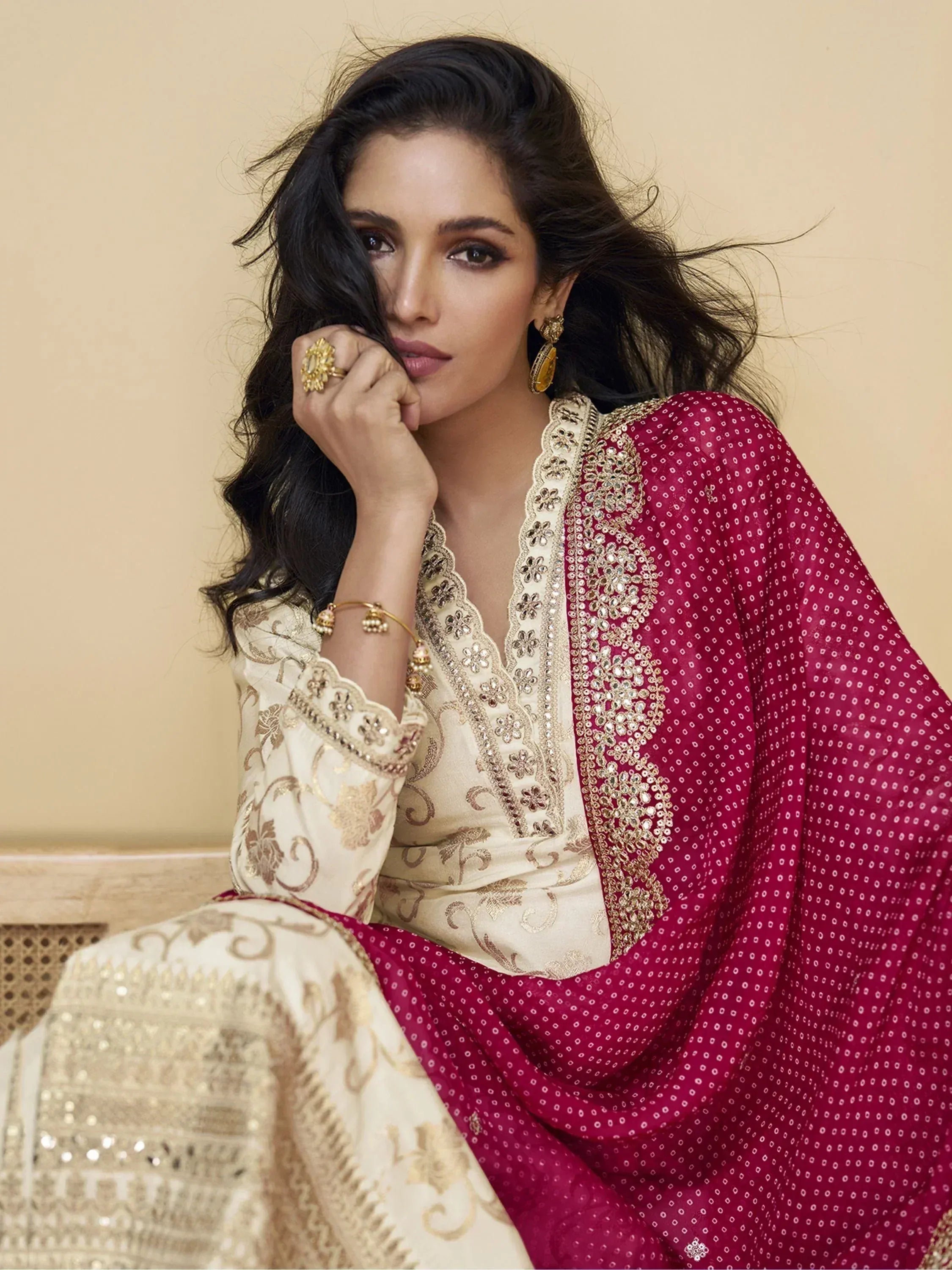 Elegant woman in embroidered cream and maroon Indian ethnic wear with gold jewelry