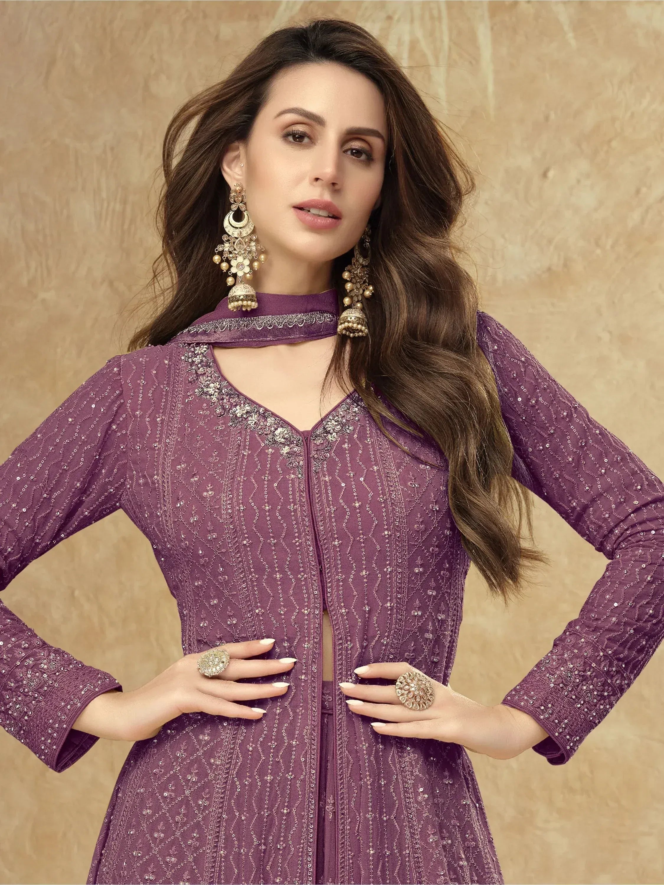 Purple embroidered ethnic gown with choker neck, statement earrings, and rings for festive occasions