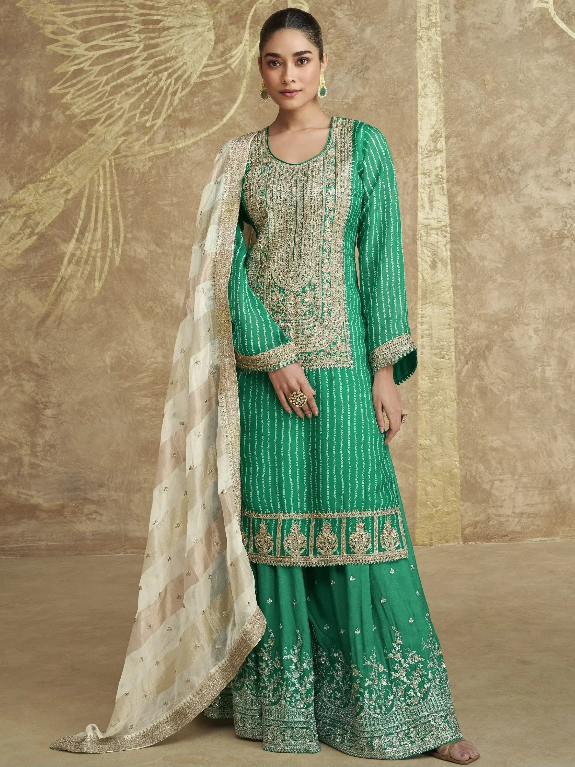 Emerald green embroidered salwar kameez with gold detailing and sheer dupatta, perfect for Indian ethnic occasions.