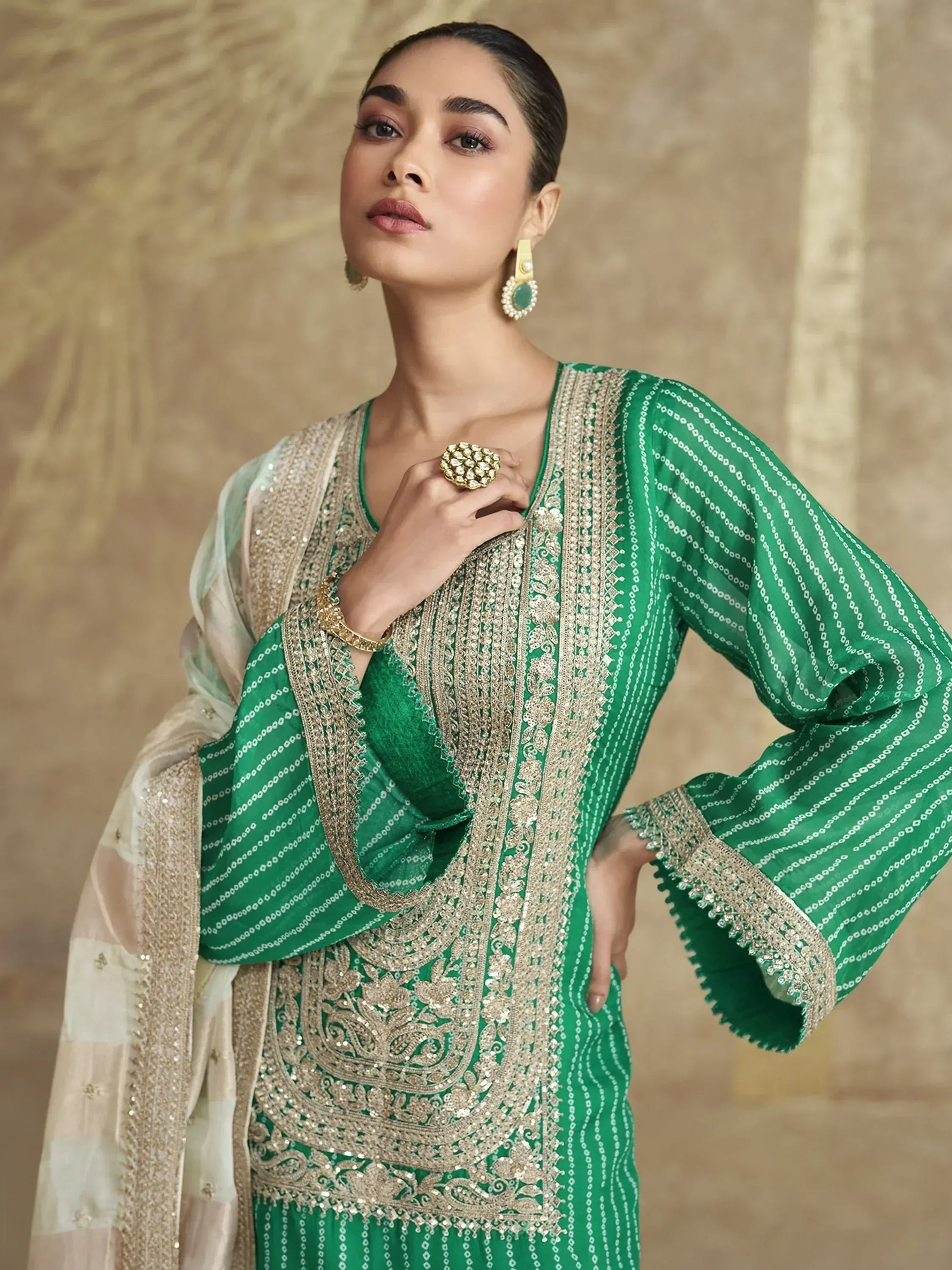 Emerald green embroidered salwar kameez with gold detailing and sheer dupatta, perfect for Indian ethnic wear