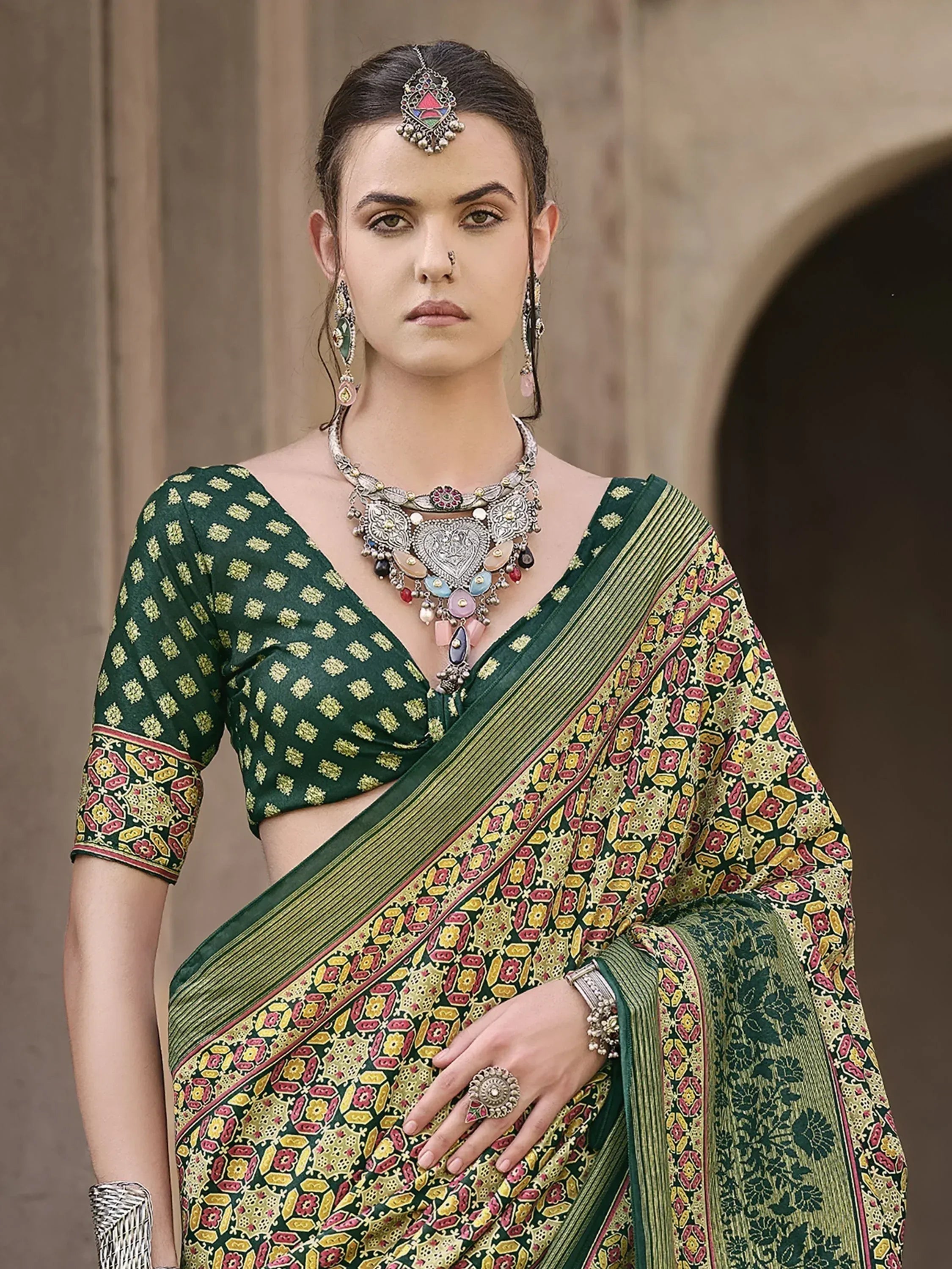 Green printed saree with floral motifs, paired with traditional jewelry for ethnic wear