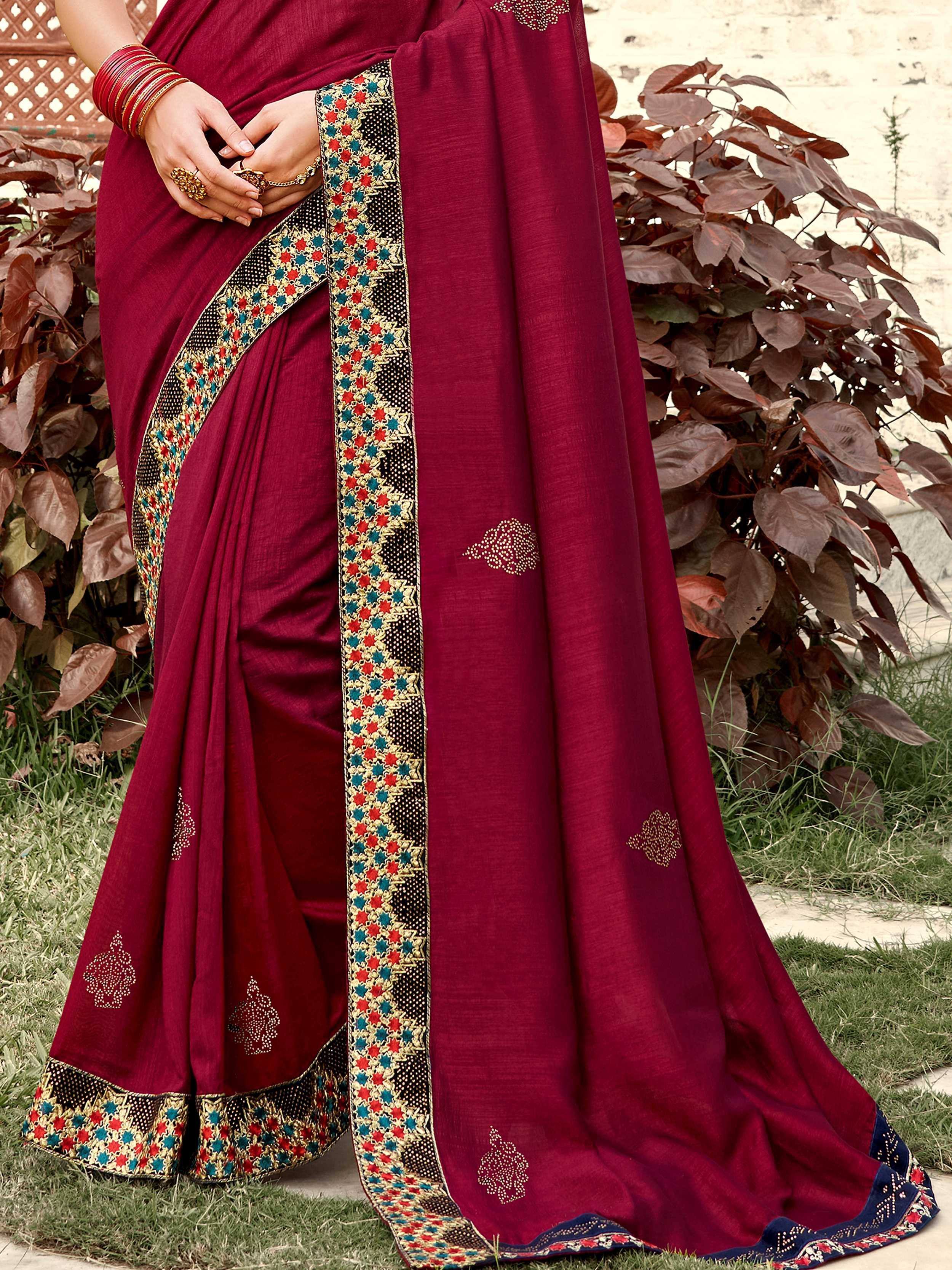 Maroon designer saree with colorful embroidered border and gold motifs, perfect for ethnic occasions