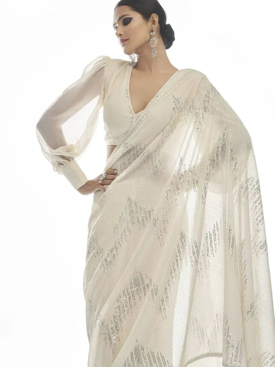 Elegant ivory saree with sequin detailing, paired with sheer puff sleeves blouse for ethnic wear