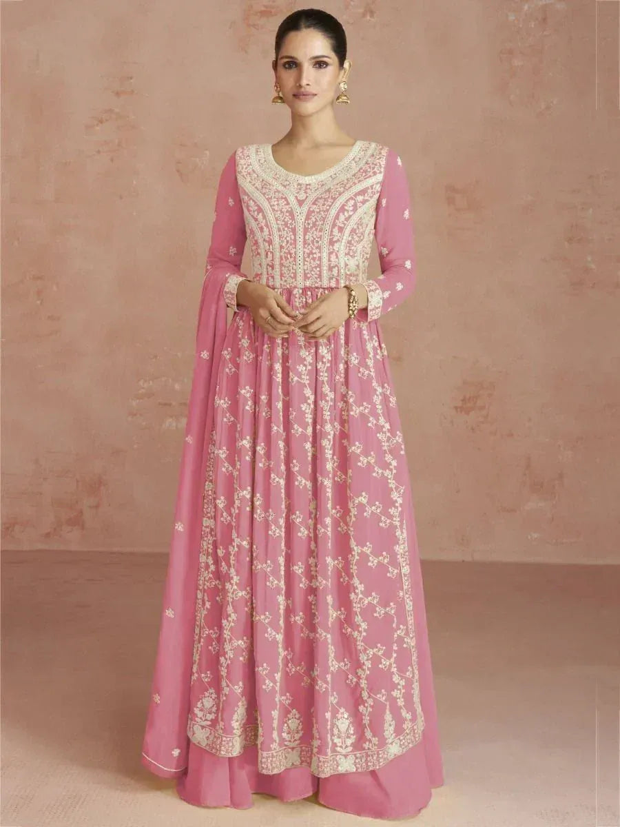 Woman wearing a pink embroidered ethnic gown with long sleeves and floral patterns