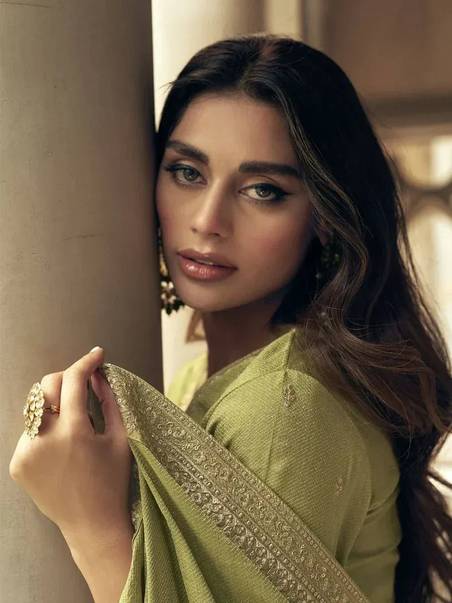 Elegant woman in olive green saree with gold embroidery, showcasing Indian ethnic wear style