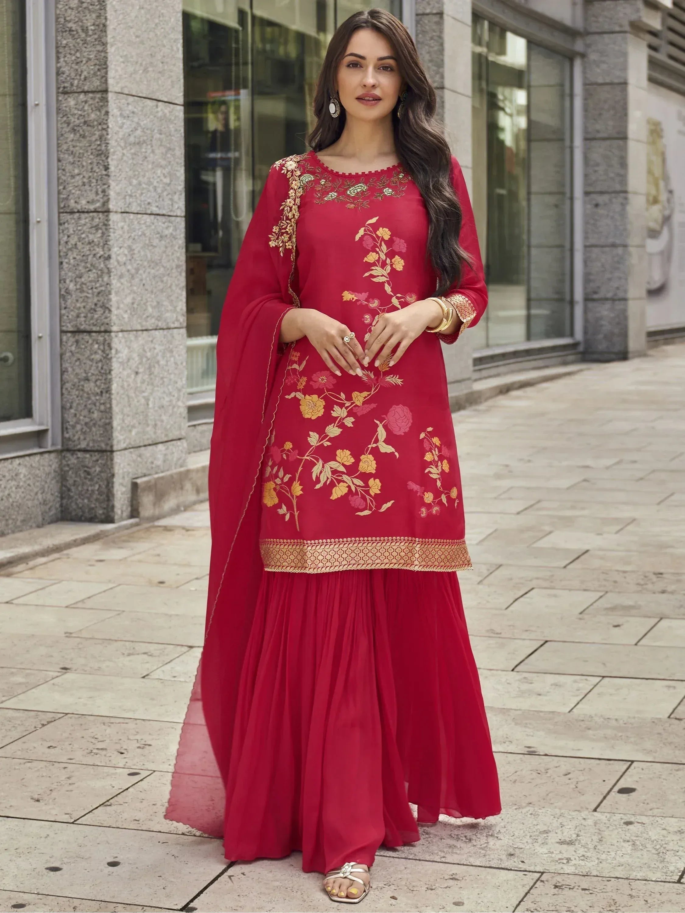 Red floral embroidered ethnic gown with gold detailing, paired with matching palazzo pants and dupatta for festive occasions
