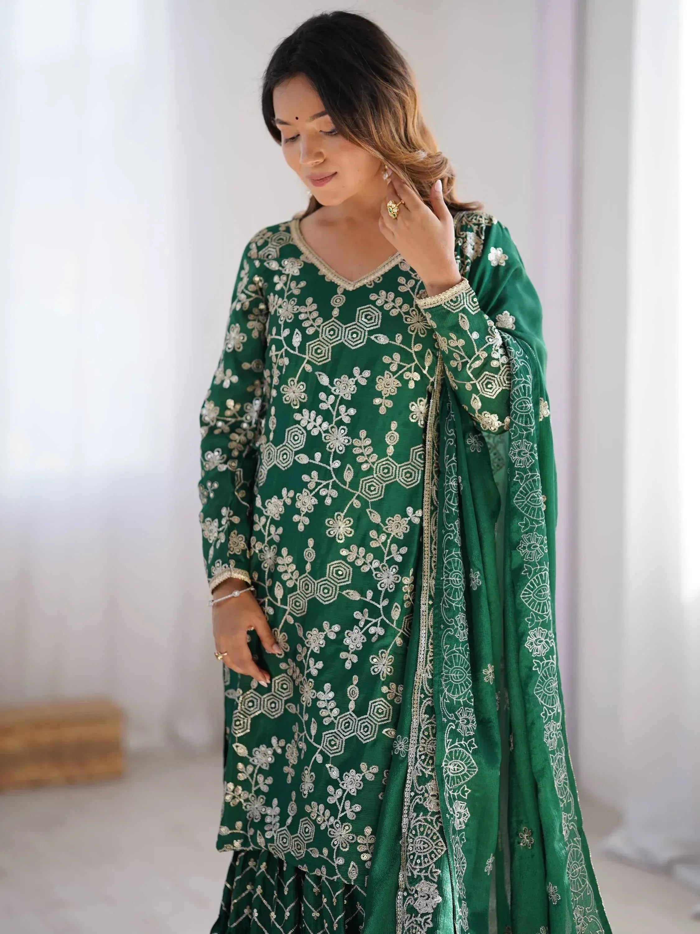 Emerald green embroidered salwar kameez with floral gold detailing, perfect for festive occasions.