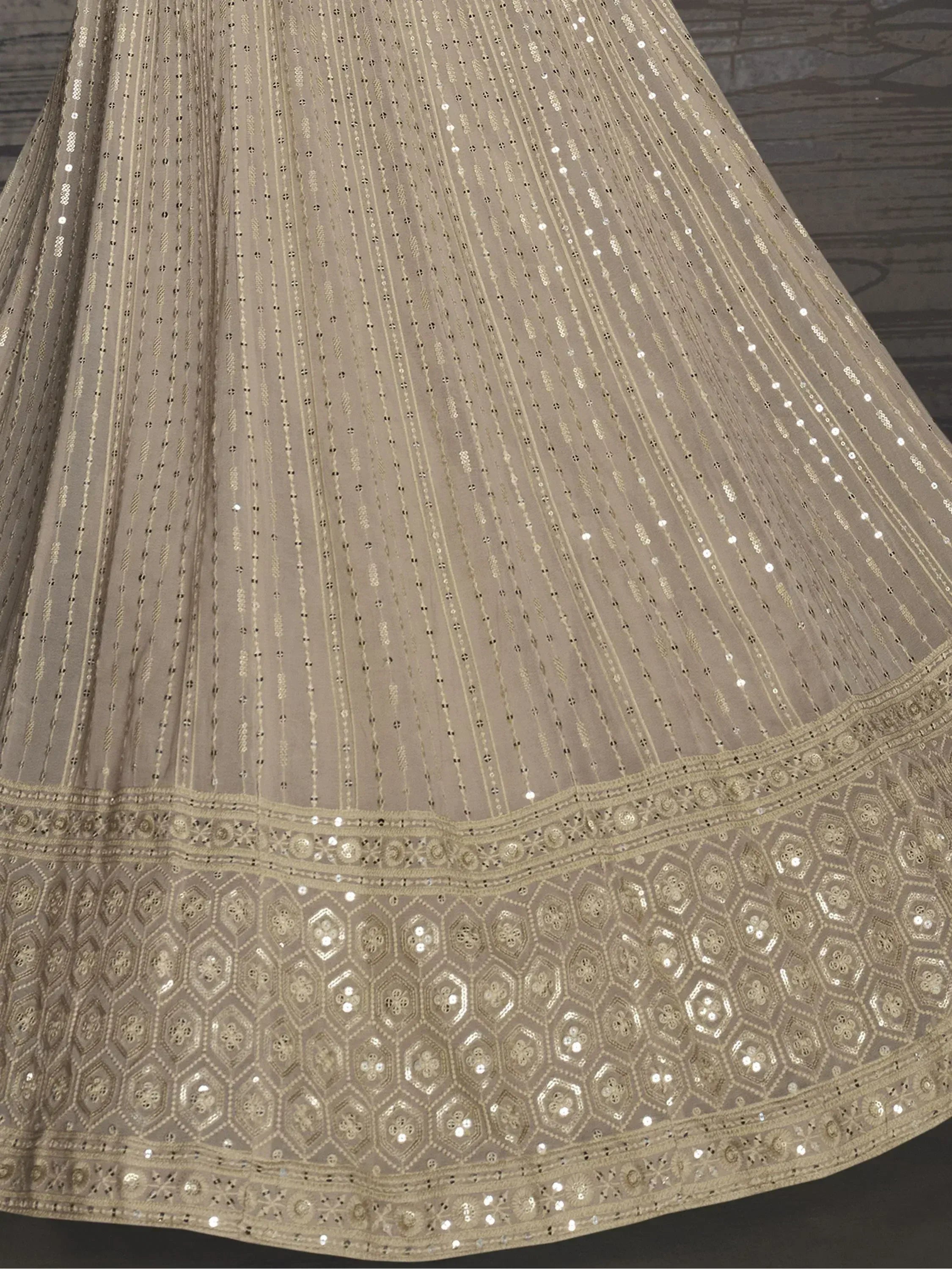 Elegant beige lehenga with intricate gold embroidery and sequin detailing, perfect for Indian ethnic wear.