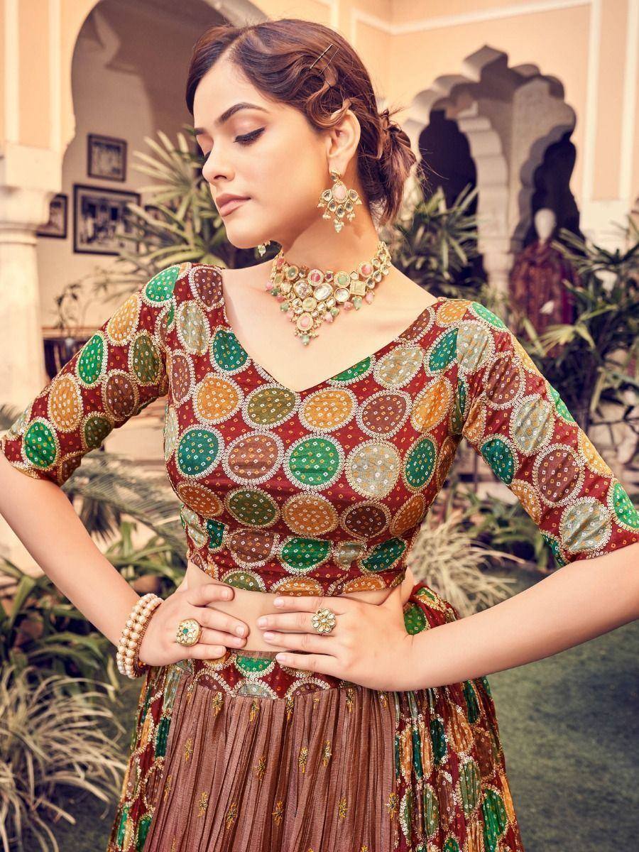 Woman in embroidered ethnic lehenga choli with colorful circular motifs, traditional jewelry, and pleated skirt