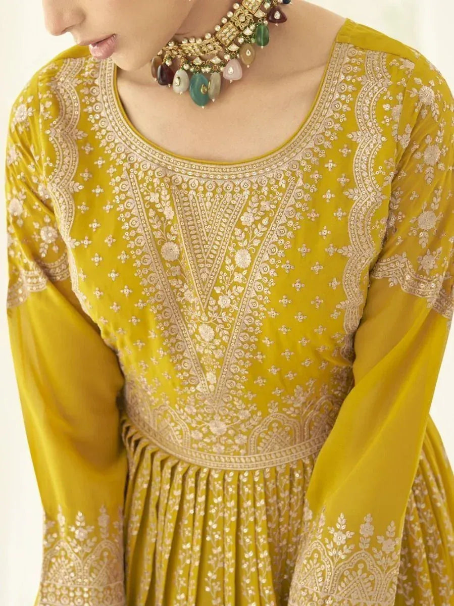 Yellow embroidered ethnic gown with intricate white floral patterns and statement necklace