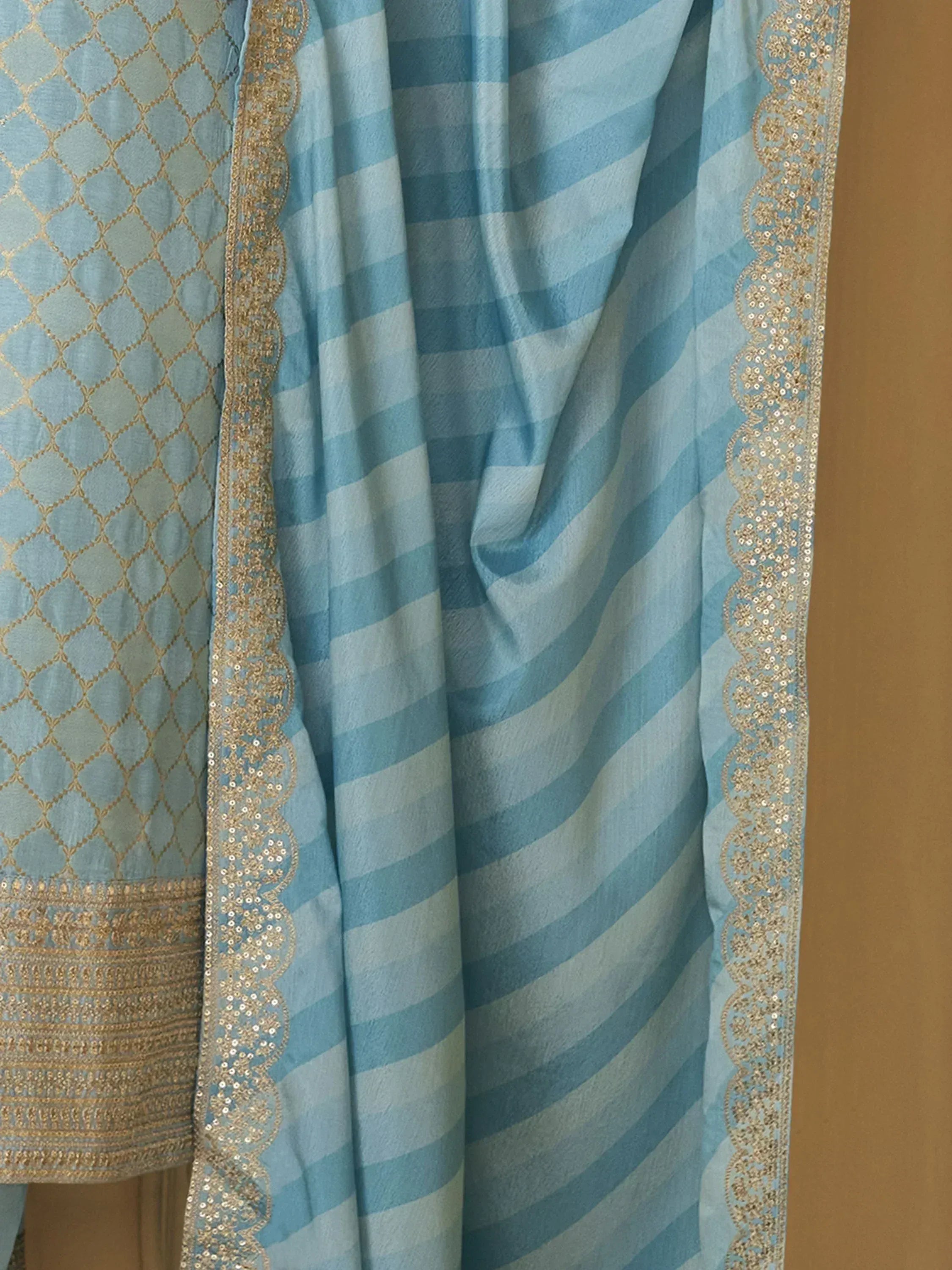 Light blue ethnic salwar kameez with gold embroidery and striped dupatta, perfect for Indian wear