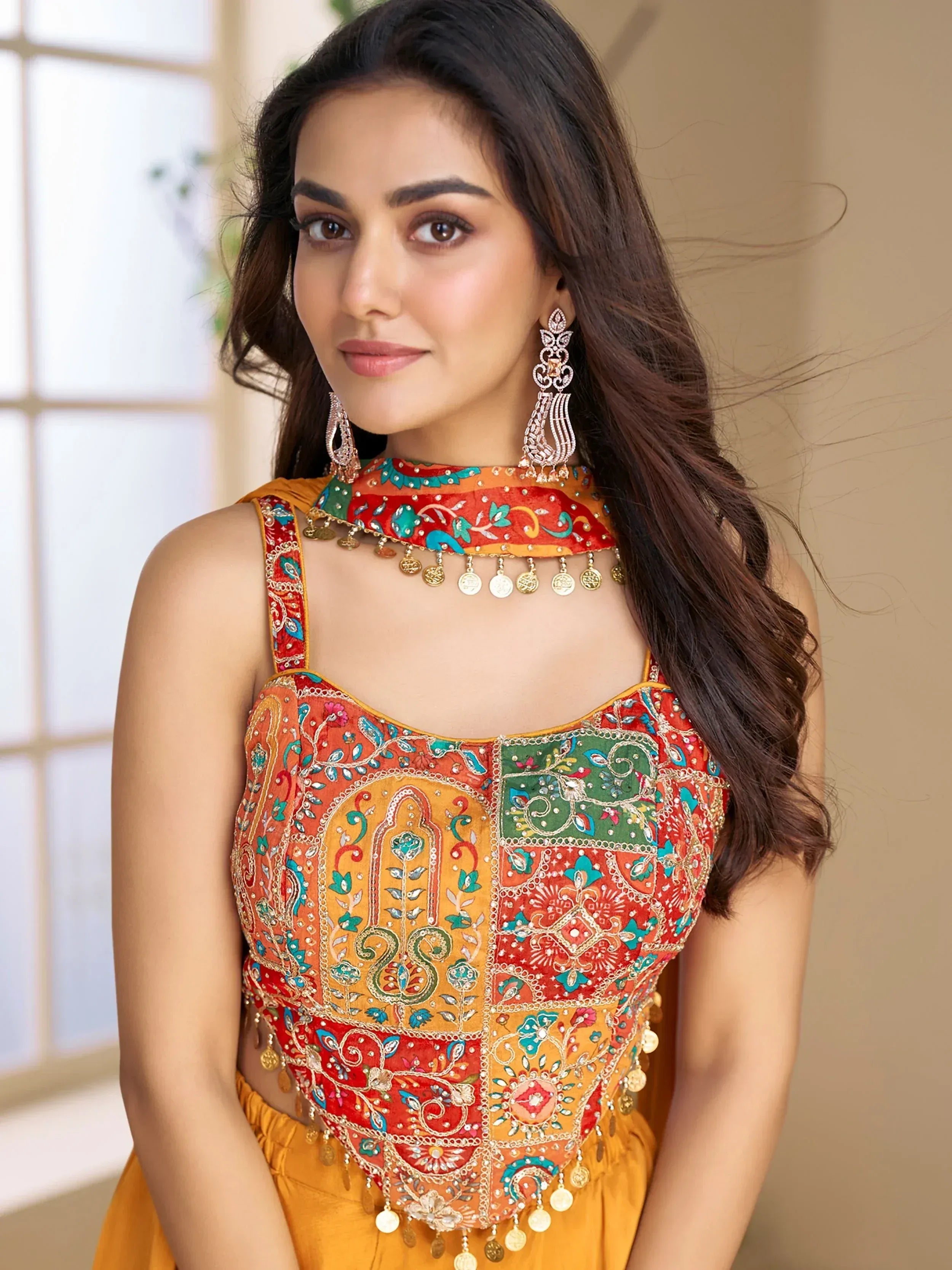 Woman in vibrant Indian ethnic wear with embroidered choli and coin detailing, perfect for festive occasions.