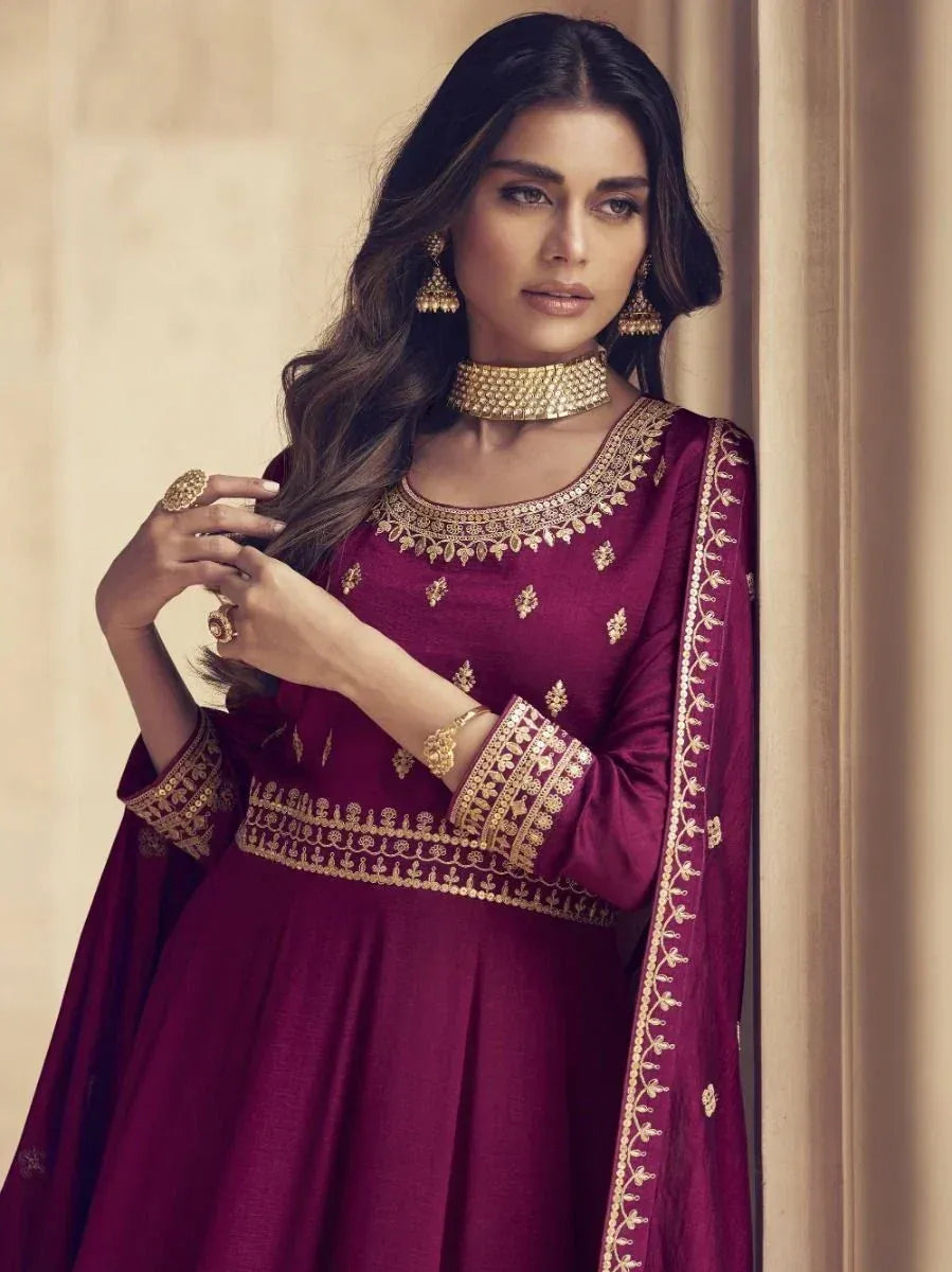 Maroon ethnic gown with gold embroidery, perfect for Indian weddings and festive occasions.
