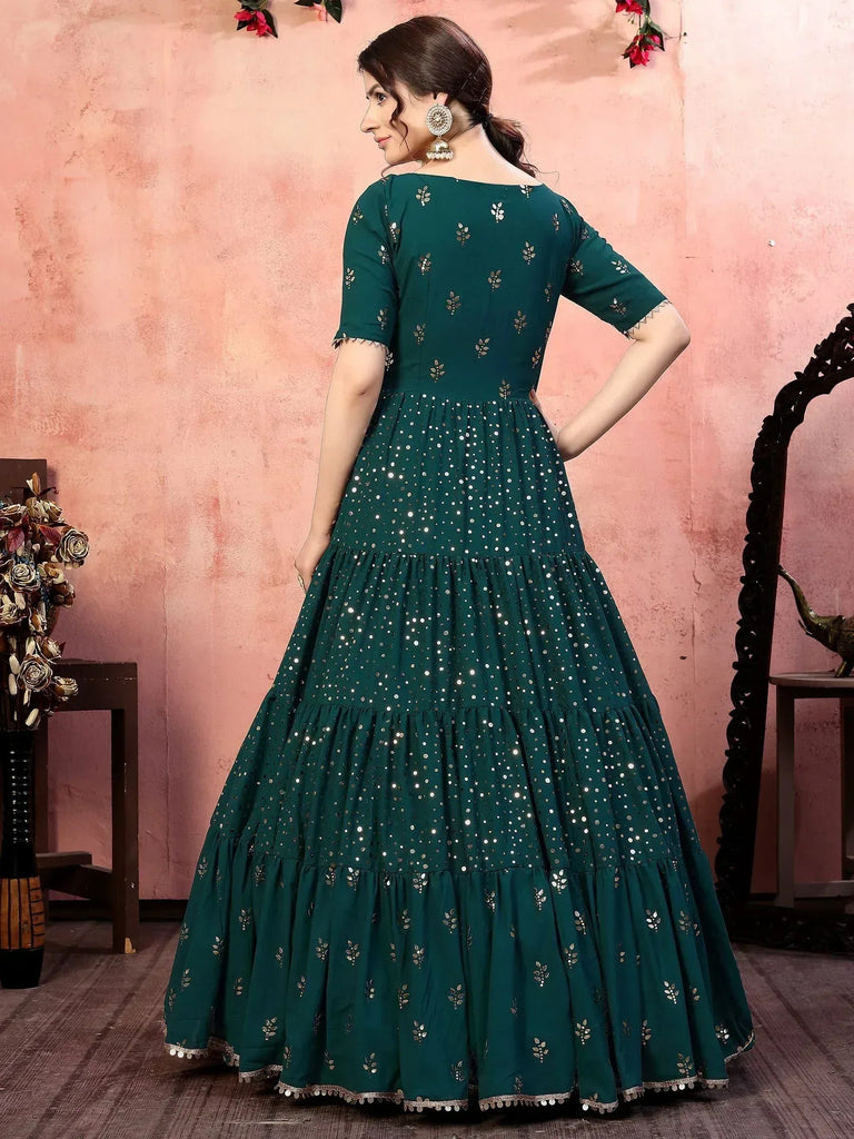 Emerald green ethnic gown with mirror work and tiered skirt, perfect for Indian festive occasions