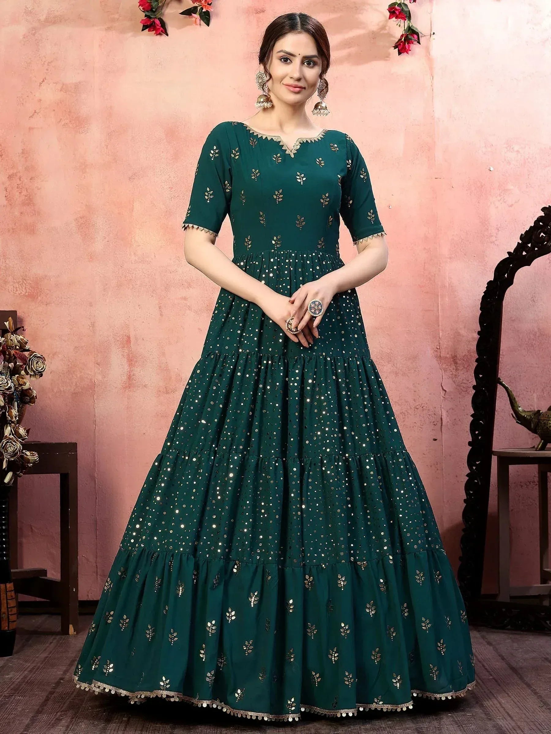 Emerald green ethnic gown with gold mirror work and tiered skirt, perfect for Indian occasions