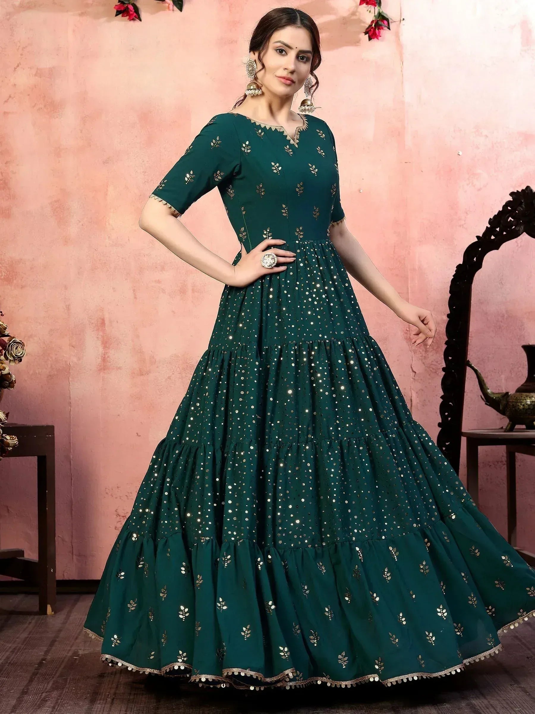 Emerald green ethnic gown with gold embroidery and mirror work, perfect for Indian celebrations.