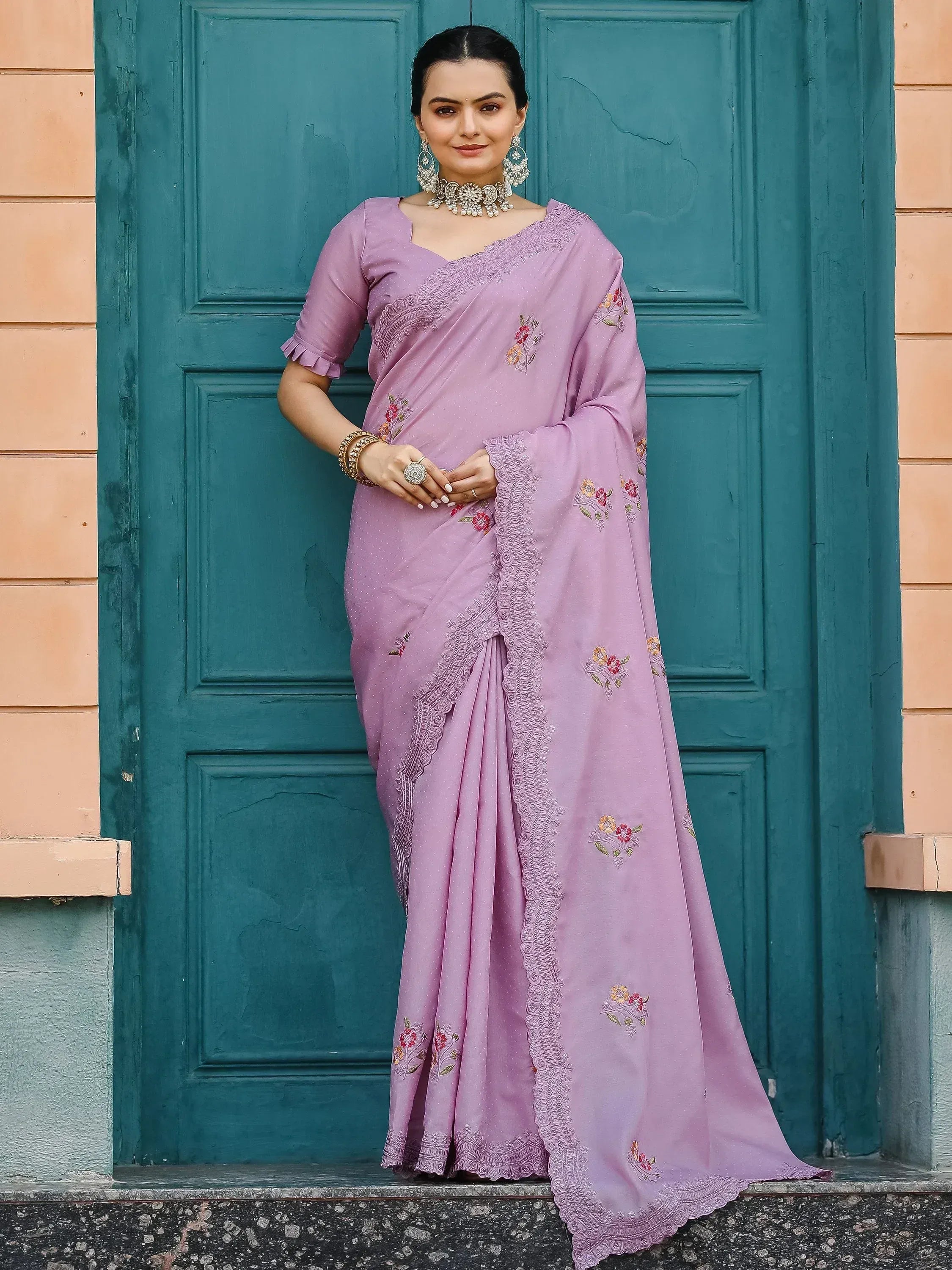 Lavender embroidered saree with floral motifs and lace border, styled with statement jewelry for ethnic occasions