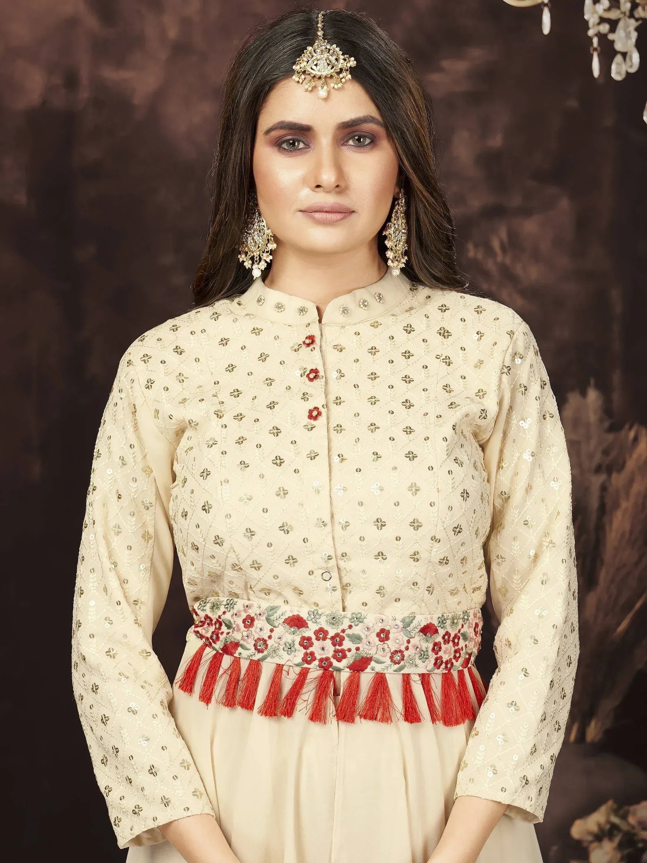Woman wearing cream embroidered ethnic gown with floral embellished belt and statement jewelry