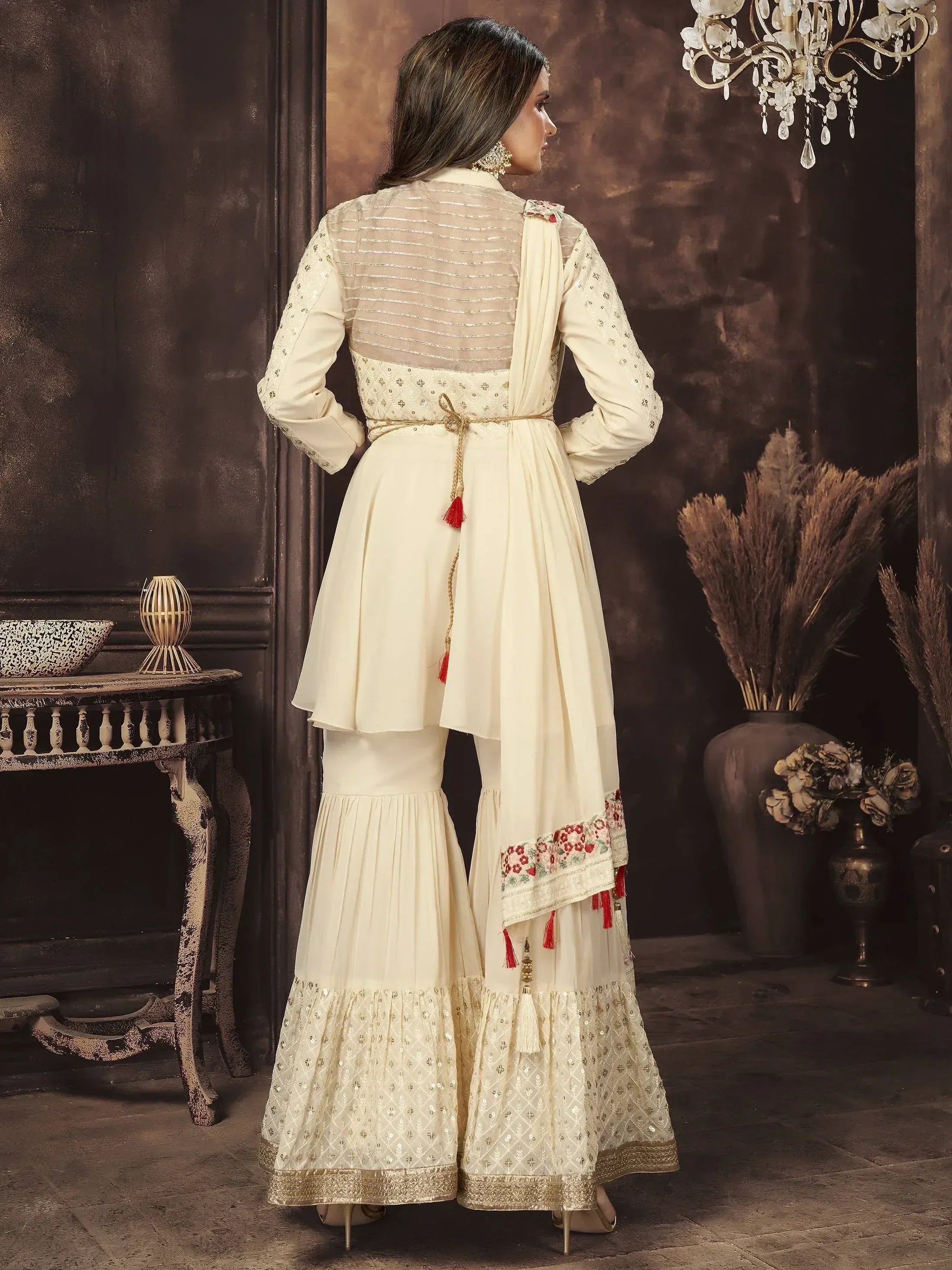 Woman wearing cream embroidered sharara suit with dupatta, traditional Indian ethnic wear