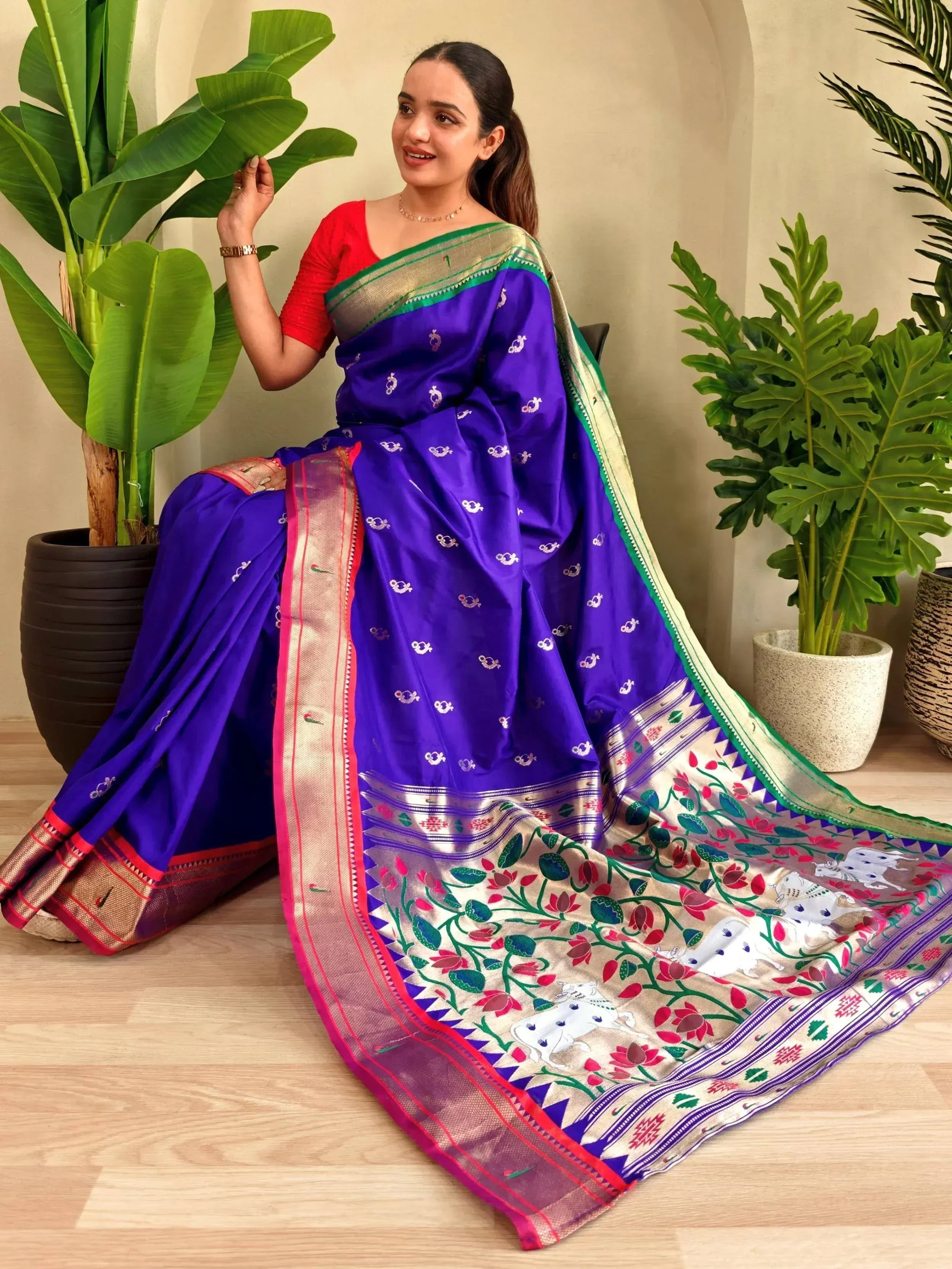 Woman in vibrant purple saree with floral and elephant motifs, paired with red blouse, ideal for Indian ethnic wear