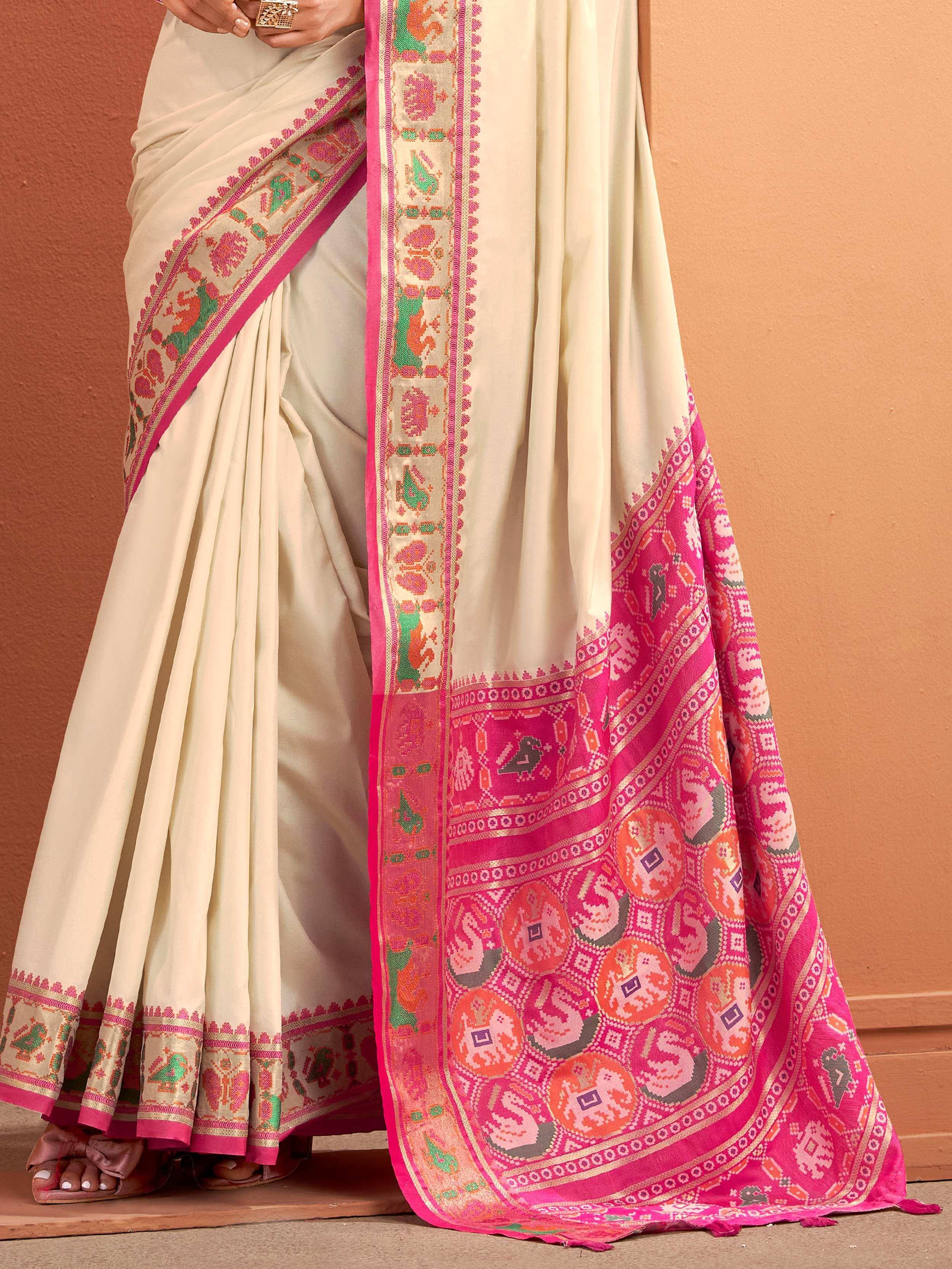 Cream saree with vibrant pink and green traditional border, perfect for Indian ethnic wear occasions.