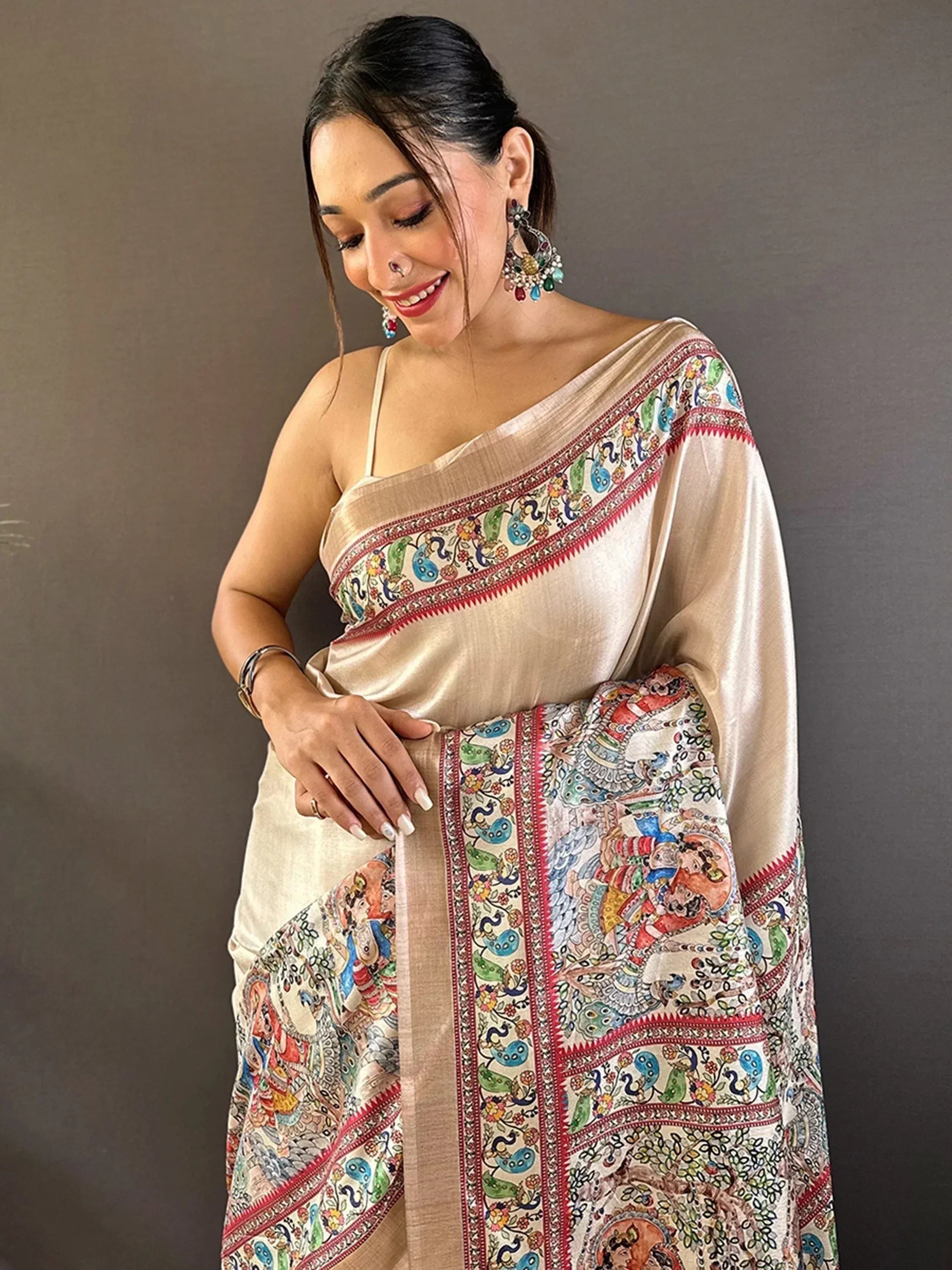 Woman in beige saree with colorful peacock and folk art print, ethnic Indian wear
