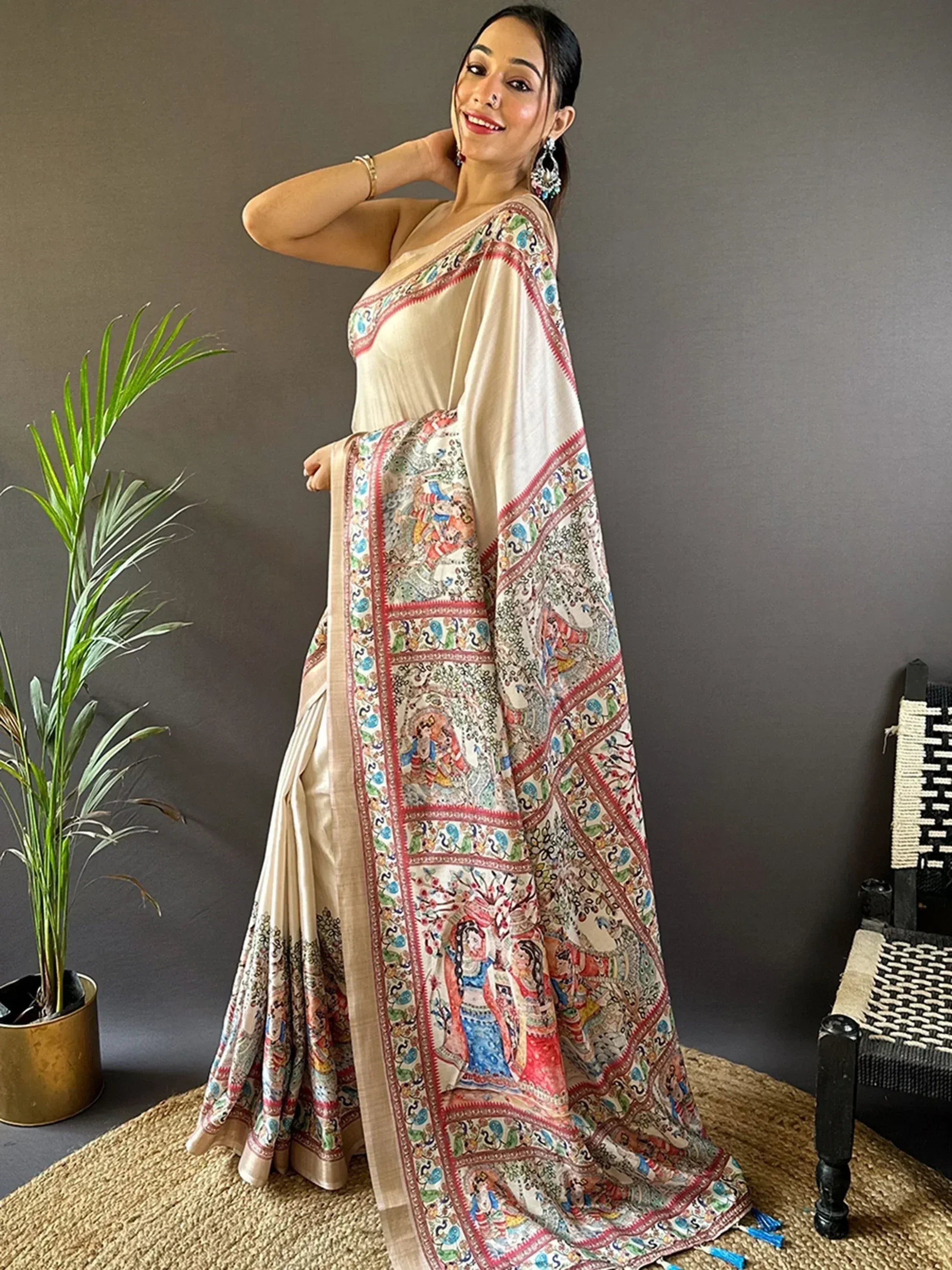 Woman in elegant cream saree with colorful traditional Indian print, perfect for ethnic occasions.