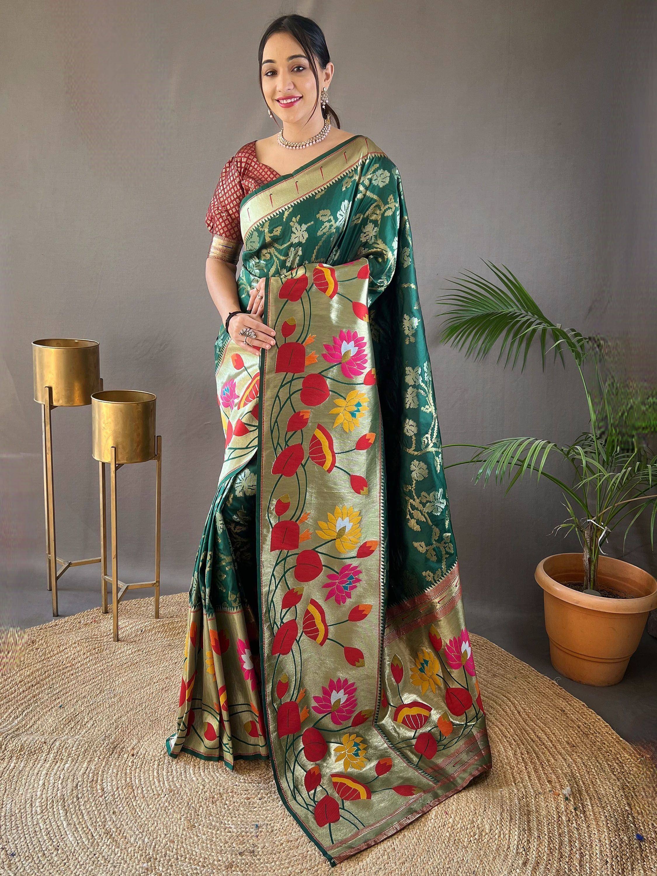 Woman in vibrant floral saree with green and gold embroidery, styled with traditional jewelry.