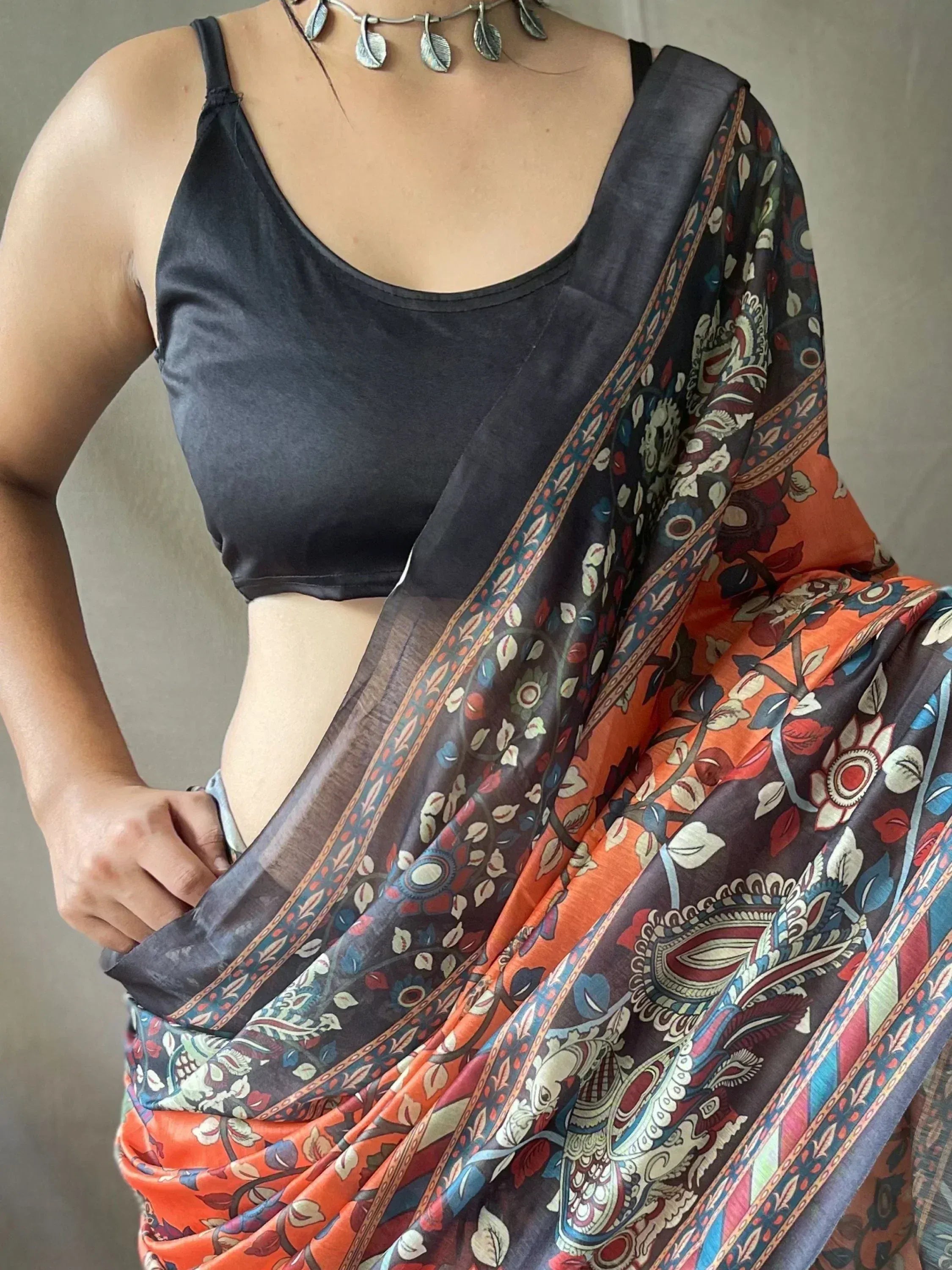 Woman in printed ethnic saree with black blouse, floral paisley design, perfect for Indian occasions