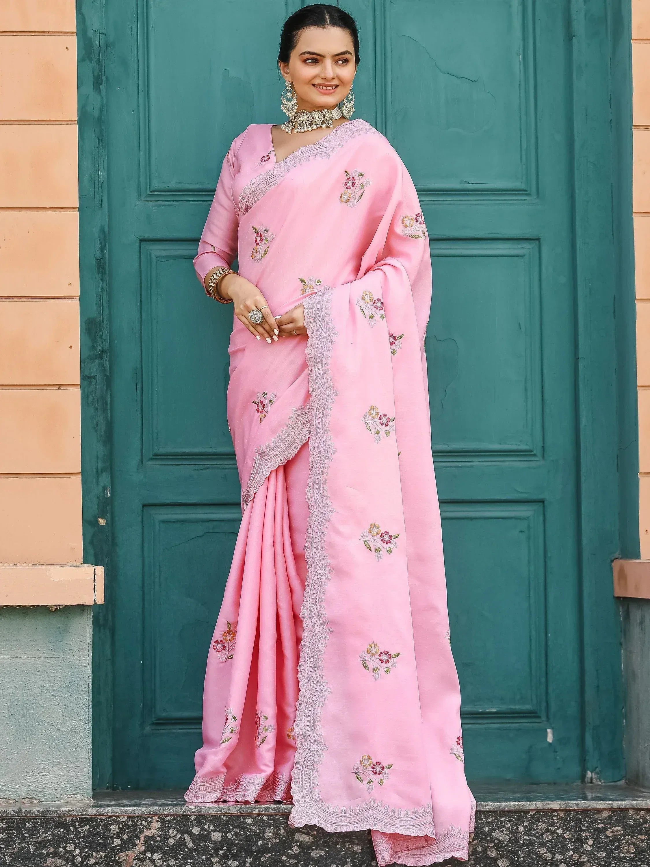 Pink floral embroidered saree with lace border, styled with traditional jewelry for ethnic wear