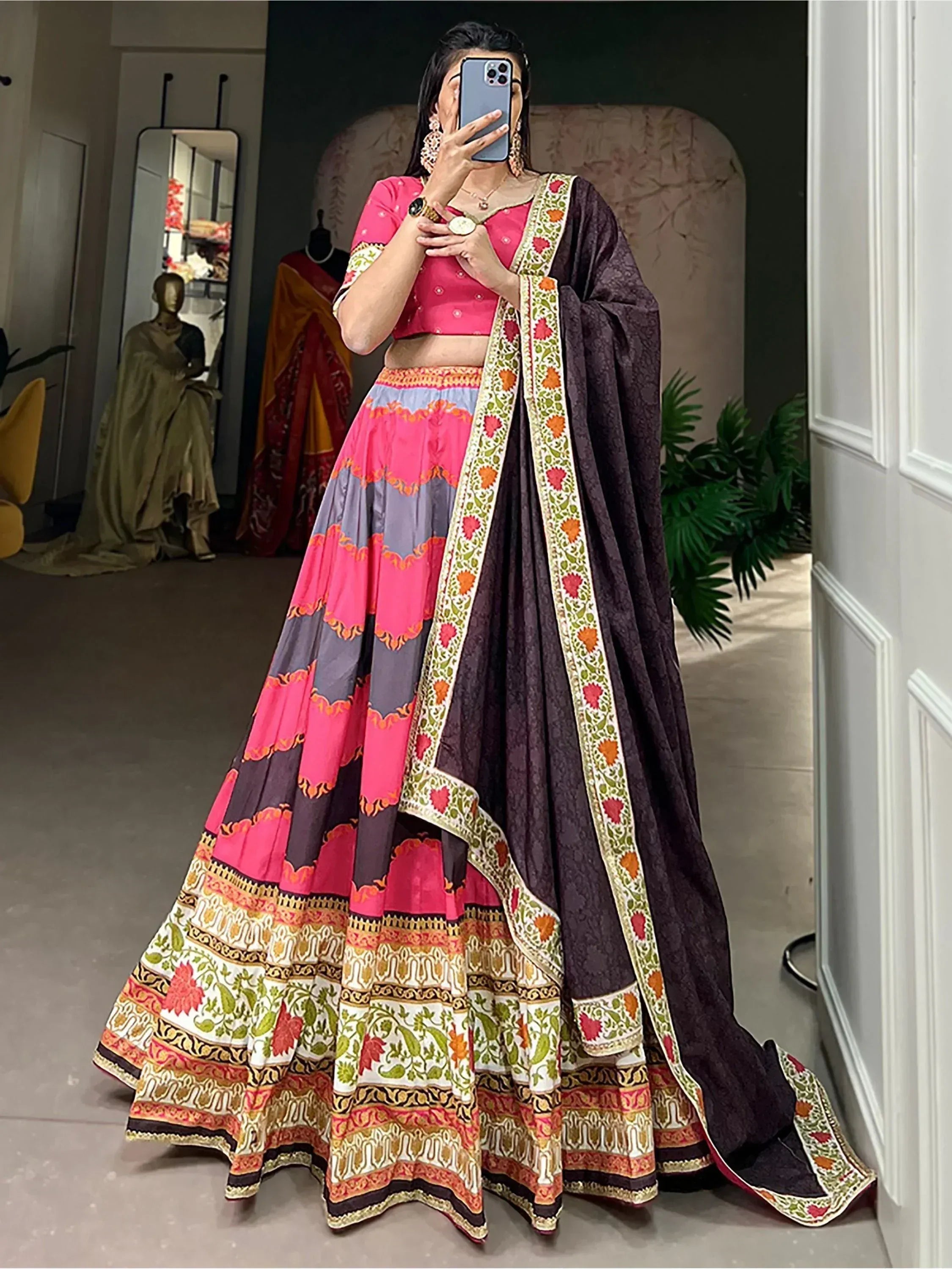 Woman in vibrant pink and purple printed lehenga choli with floral dupatta, ethnic Indian wear