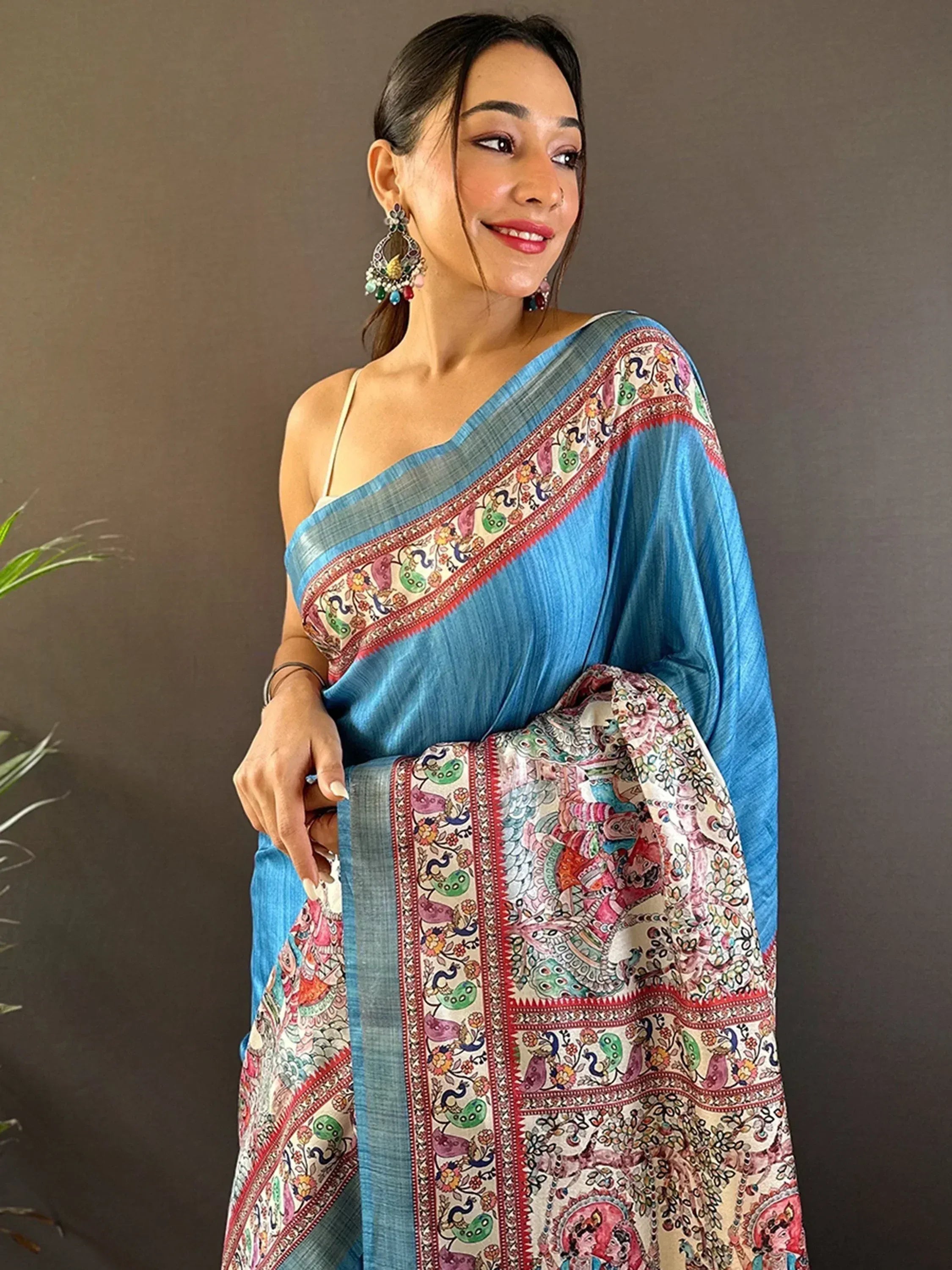 Woman in blue printed saree with colorful paisley border, ethnic Indian wear