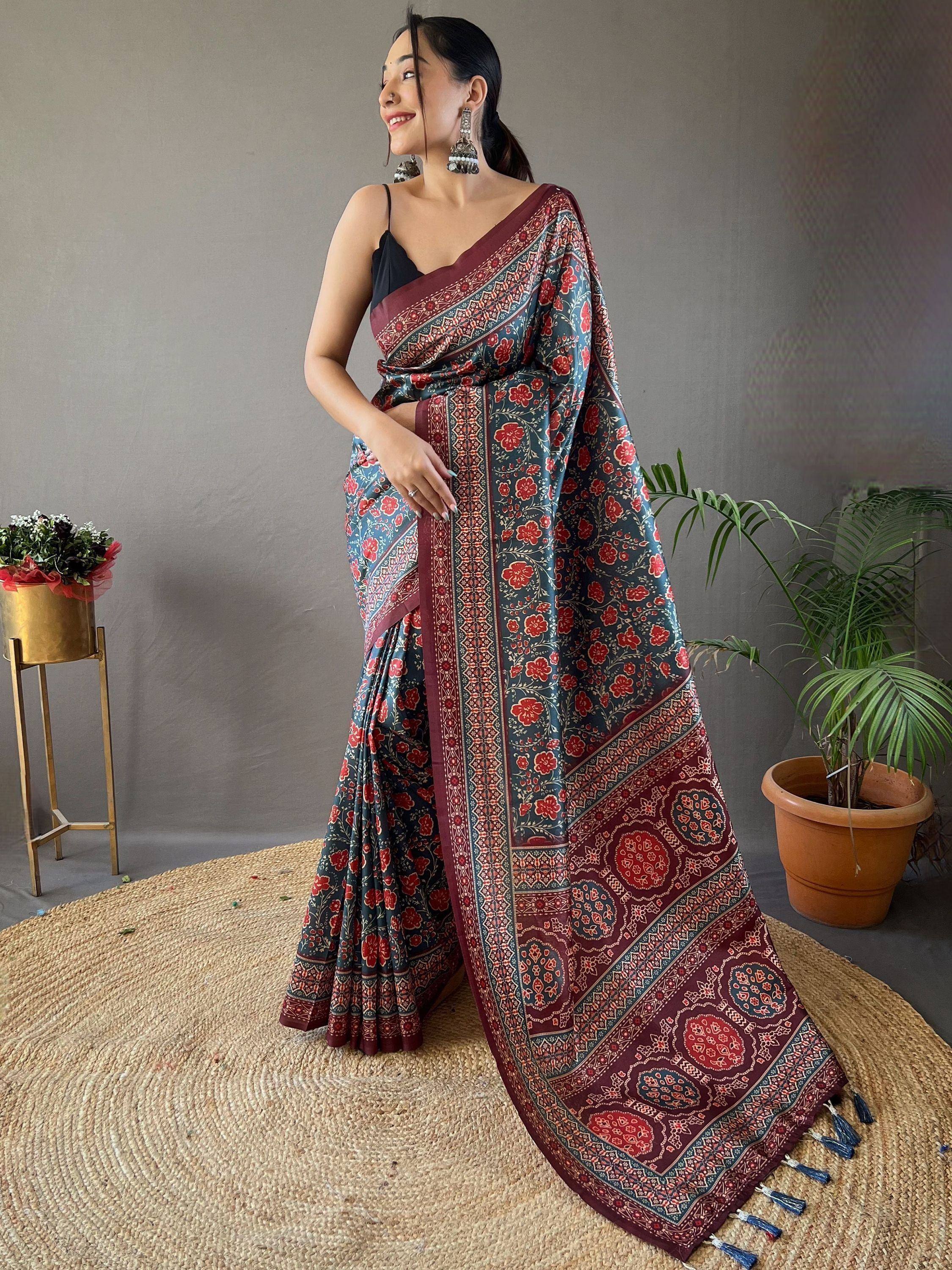 Woman in floral printed Indian saree with maroon border and tassels, styled with black blouse for ethnic wear