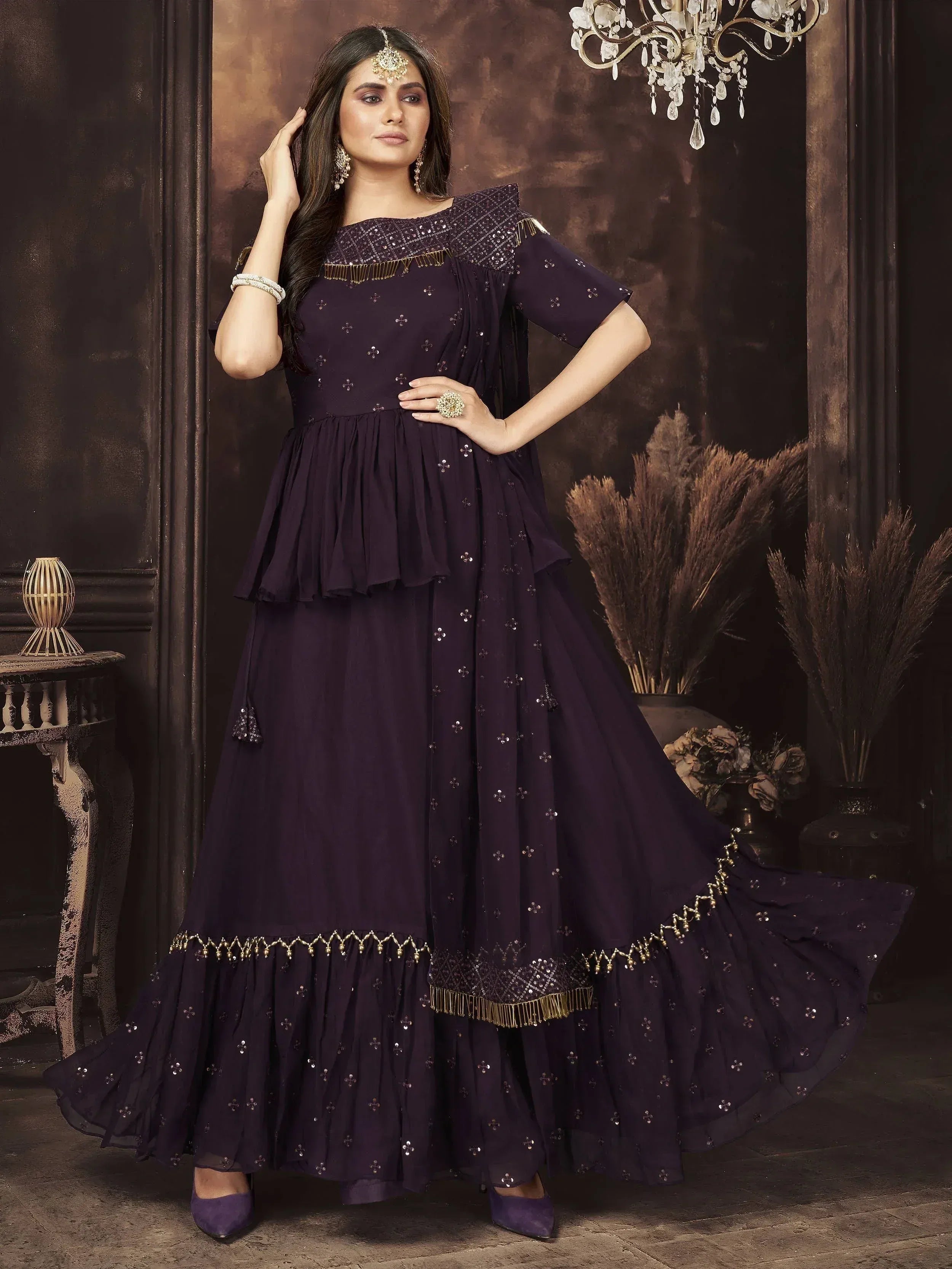 Elegant purple ethnic gown with gold embroidery and layered skirt, perfect for Indian festive occasions.
