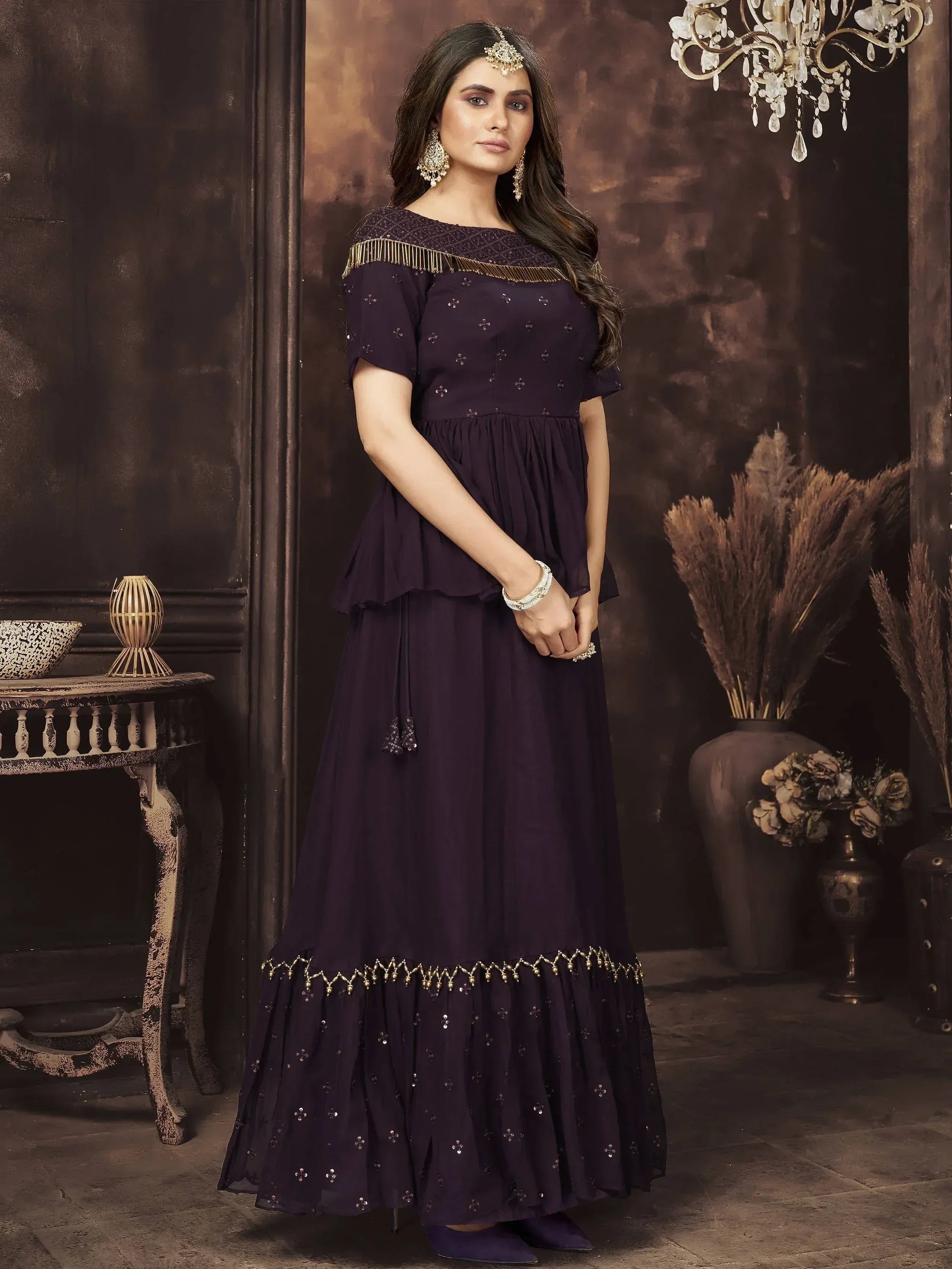 Elegant purple ethnic gown with gold embroidery and fringe, perfect for Indian festive occasions.